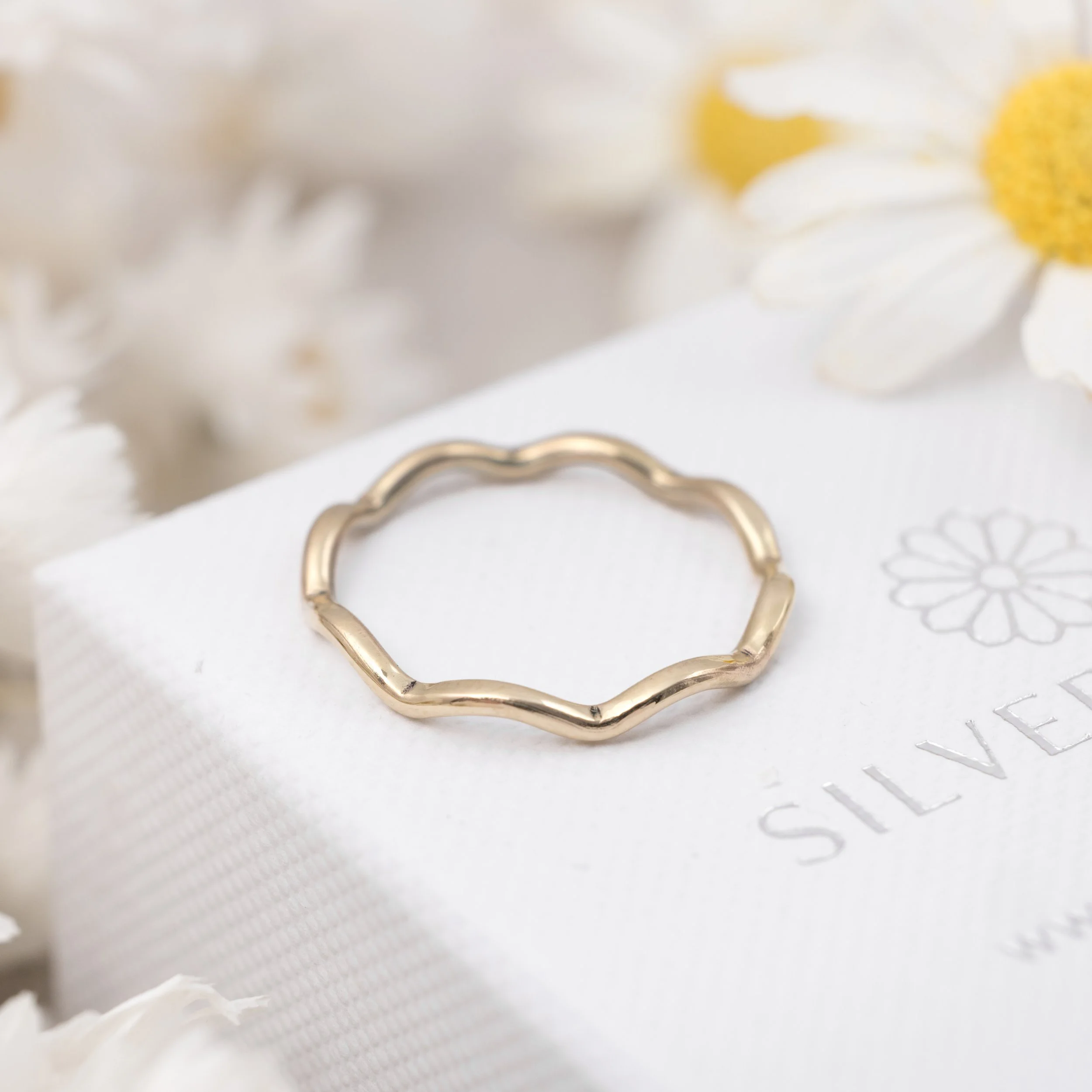 9ct yellow gold wave stacking ring with a polished curved band designed for layering or wearing solo.