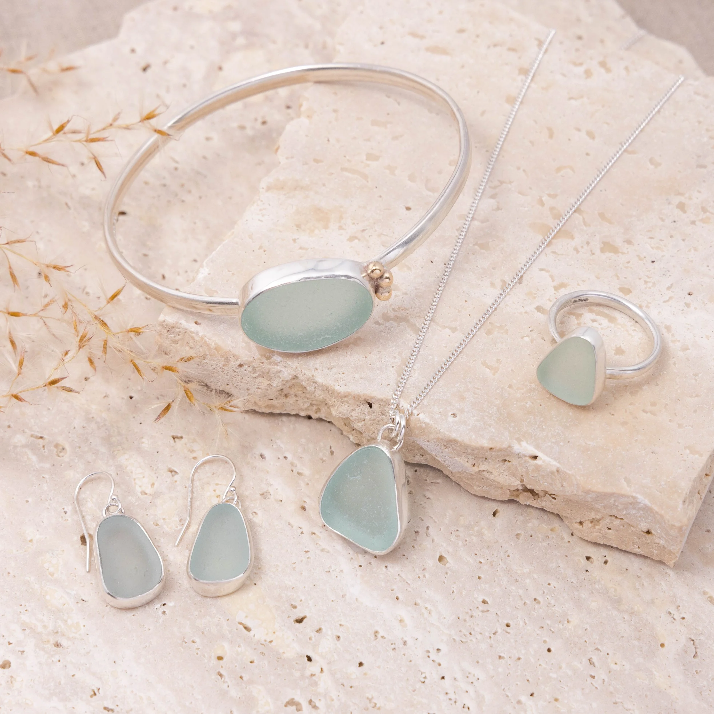 Aqua sea glass pebble set in polished silver on a delicate chain, coastal-inspired handmade necklace.
