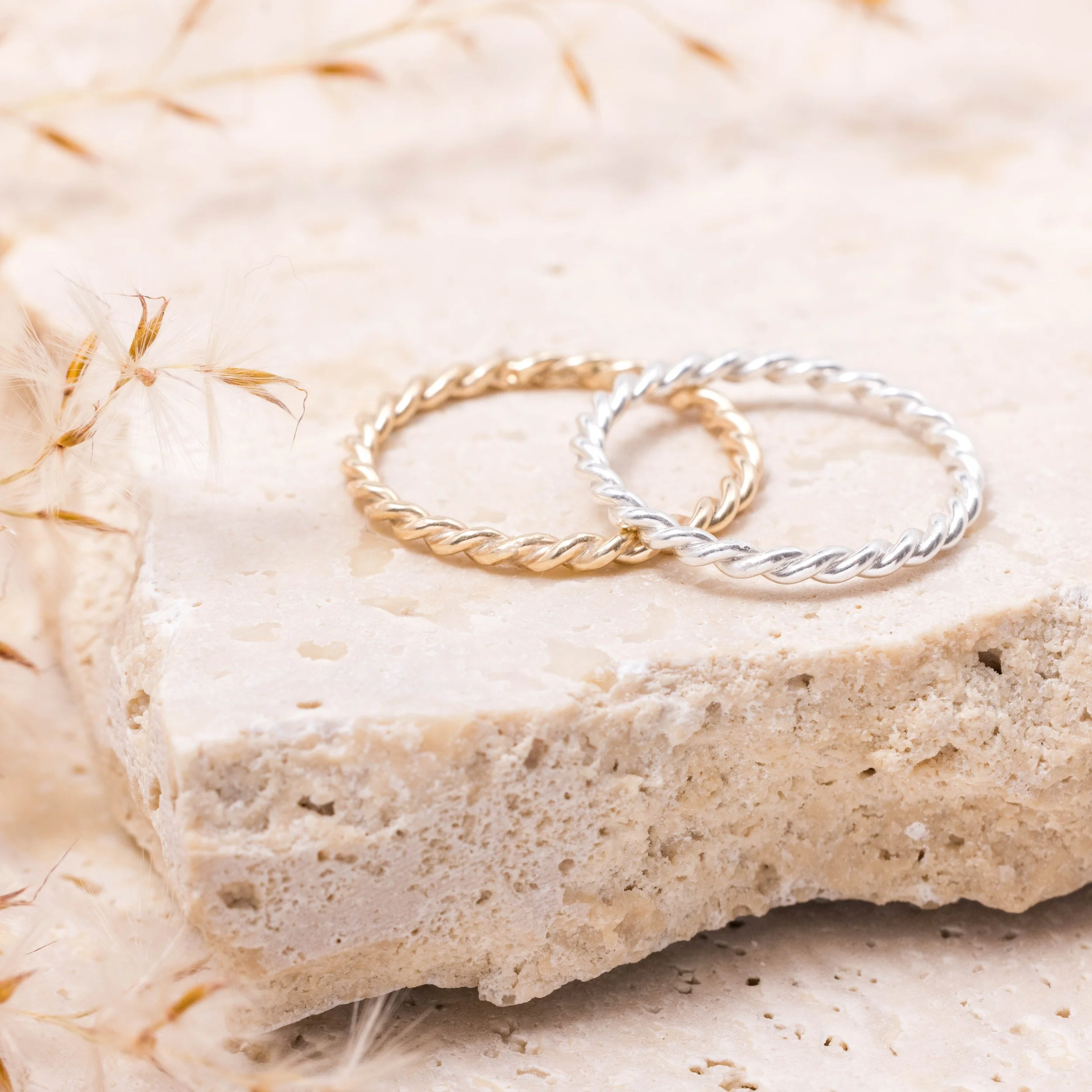 Polished sterling silver twist stacking ring with a delicate rope design, ideal for layering or wearing alone.