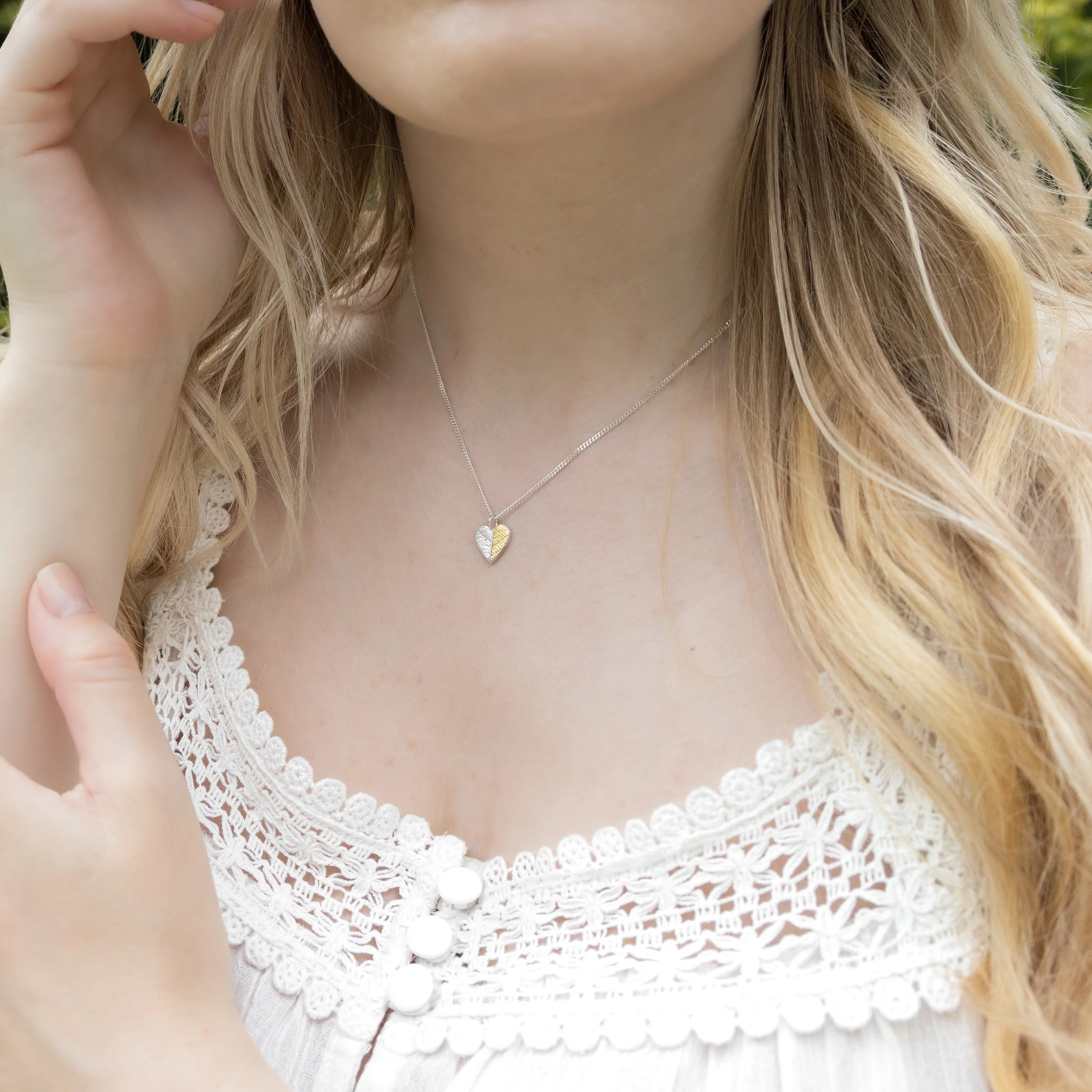 Gold and silver heart leaf pendant necklace with textured leaf pattern on a fine silver chain, handmade botanical jewellery.
