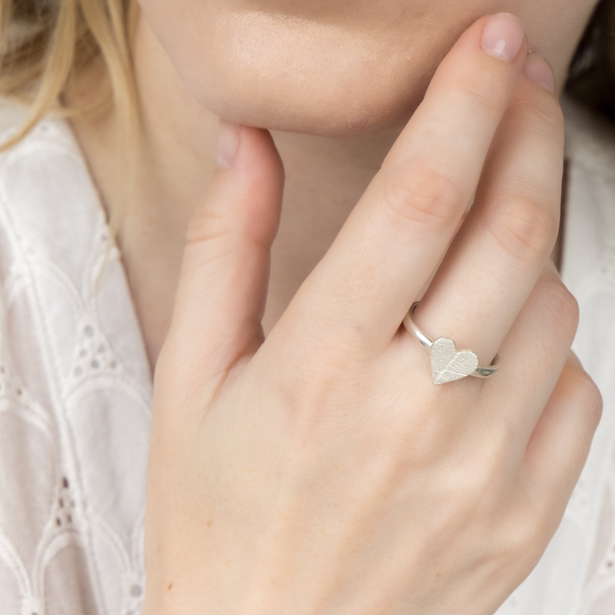 Sterling silver heart-shaped ring with delicate pressed leaf pattern on a polished band.