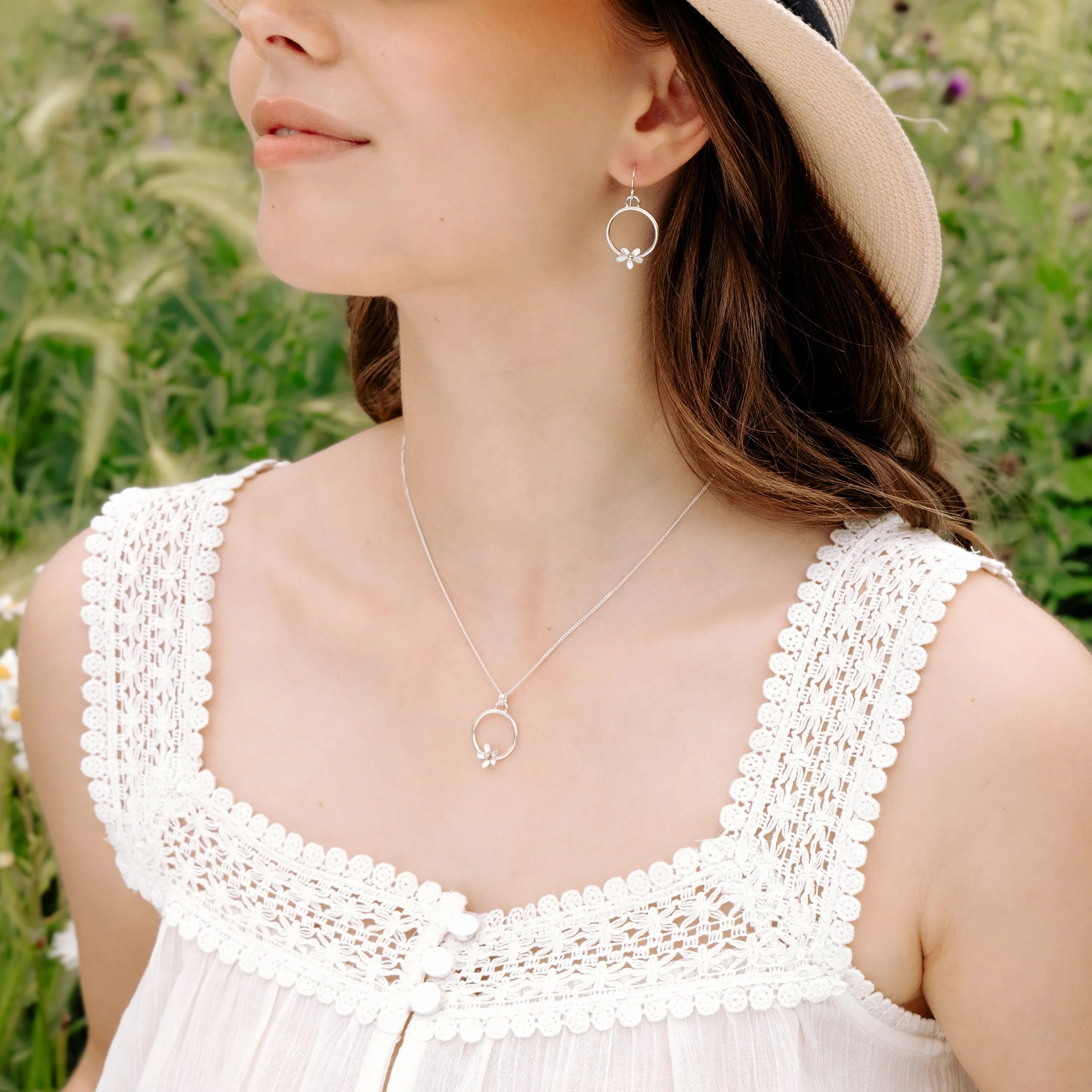 Sterling silver hoop earrings with delicate daisy flower charms, featuring 9ct gold stamen, and a polished and lightweight finish.