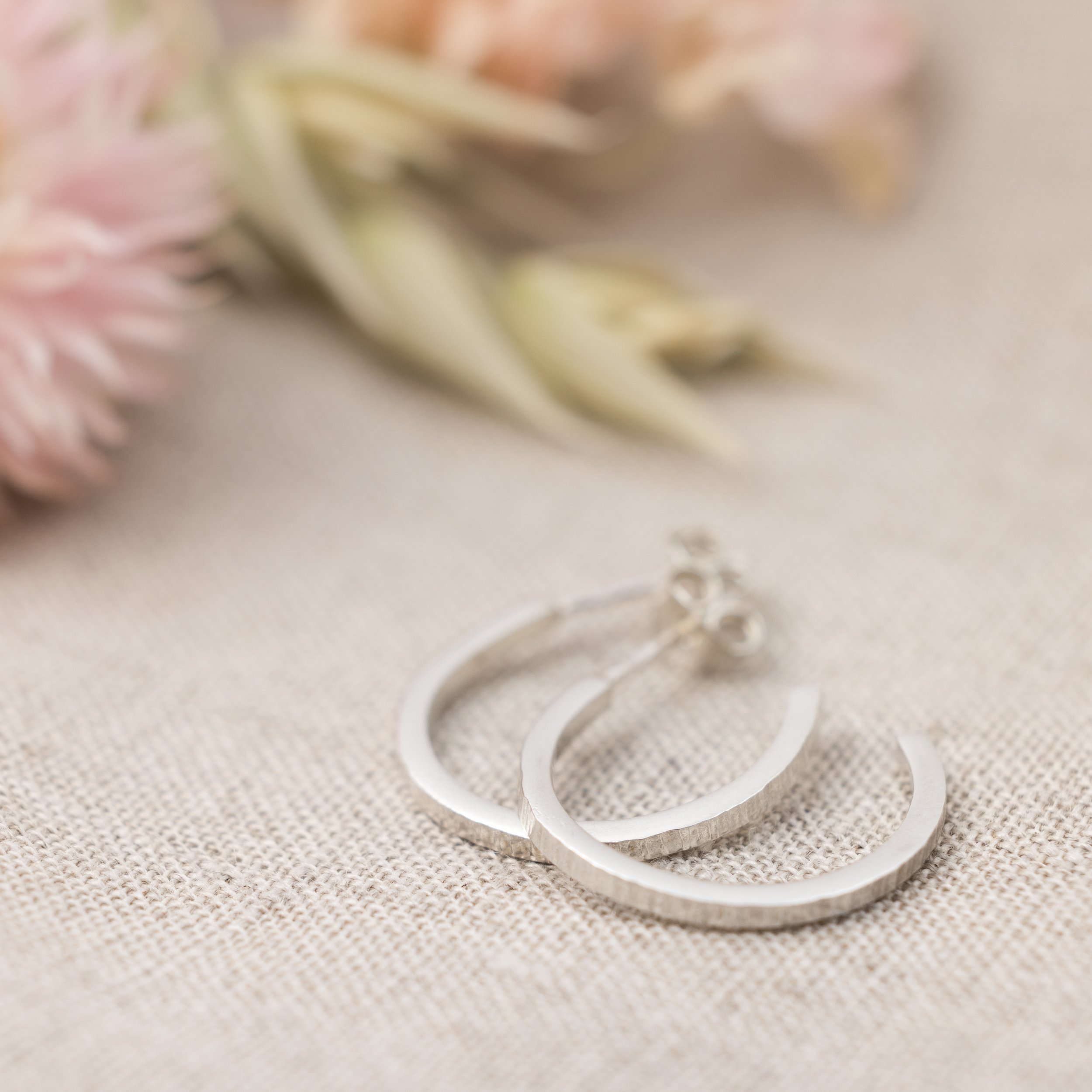 Sterling silver hoop earrings with a hammered texture, polished finish, and lightweight modern design for everyday wear.