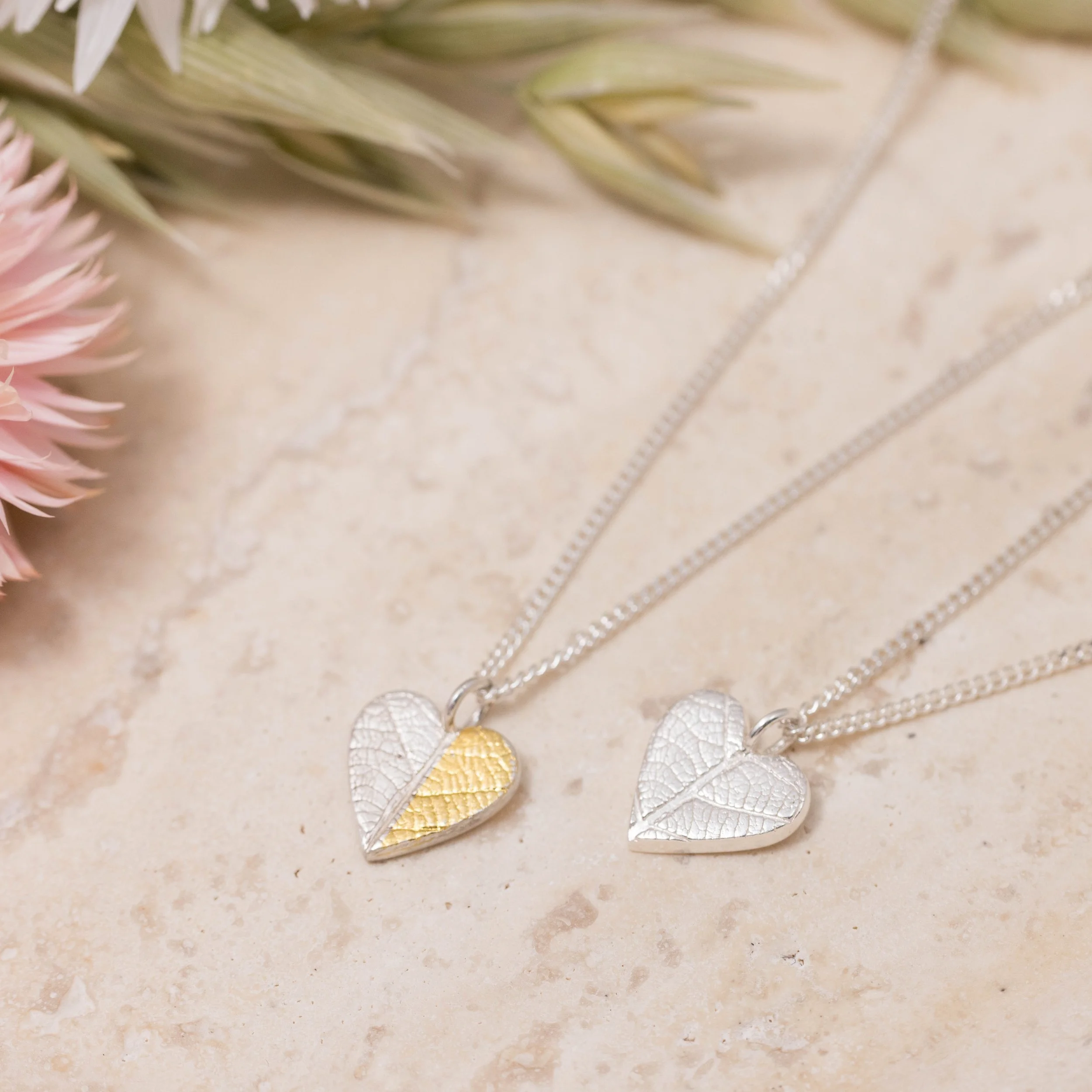 Gold and silver heart leaf pendant necklace with textured leaf pattern on a fine silver chain, handmade botanical jewellery.