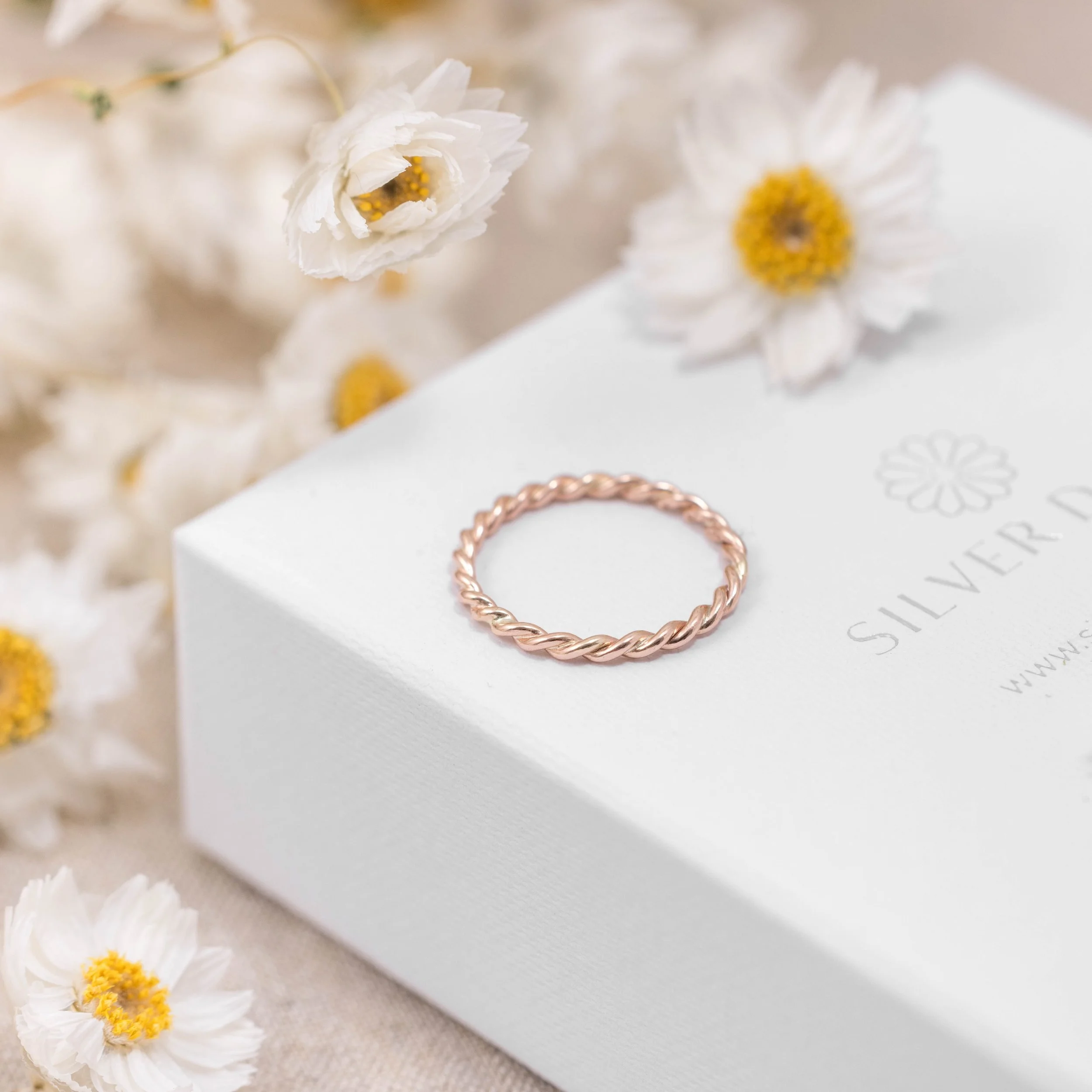 Delicate 9ct rose gold stacking ring with a twisted rope design, polished finish, ideal for layering or wearing as a minimalist band.