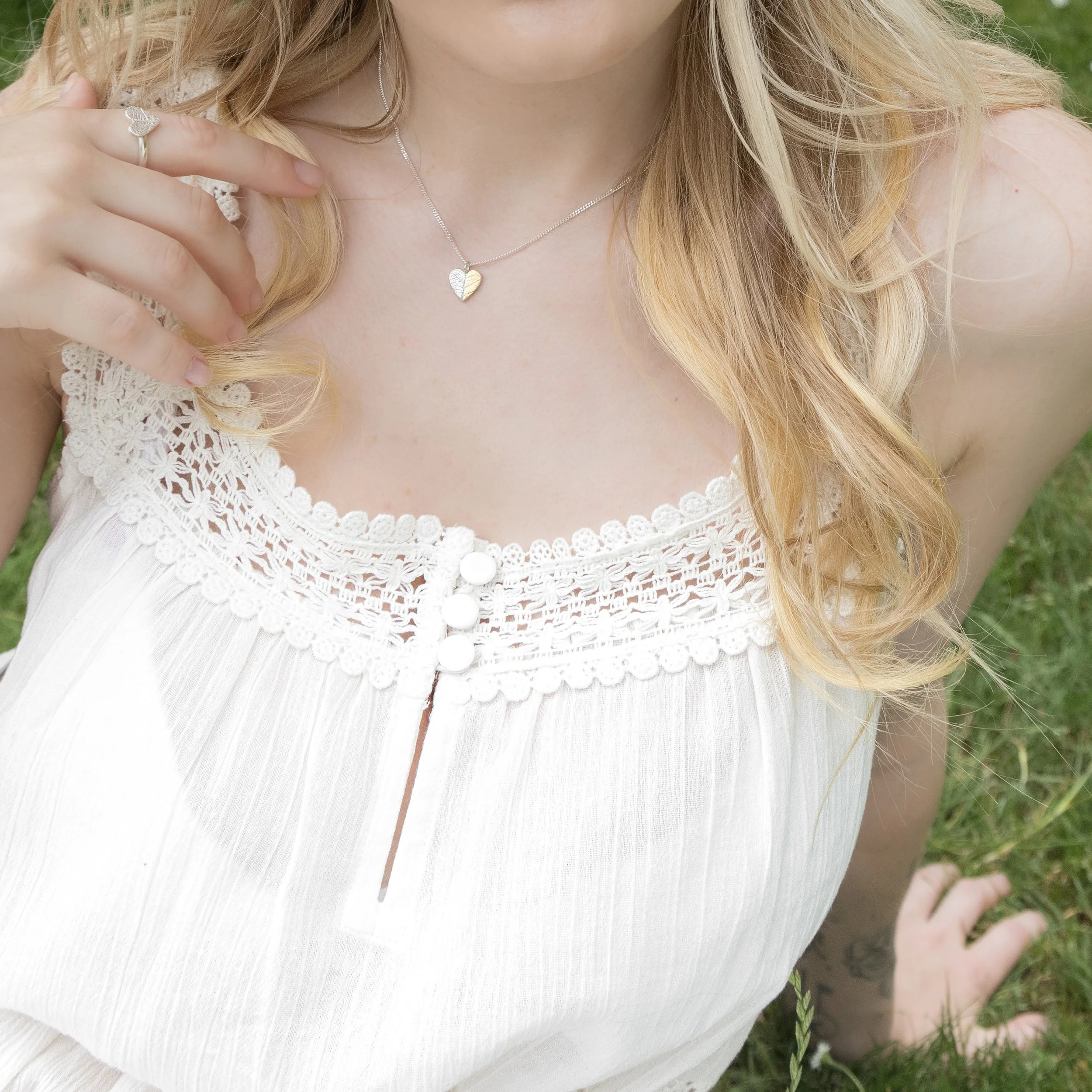 Gold and silver heart leaf pendant necklace with textured leaf pattern on a fine silver chain, handmade botanical jewellery.