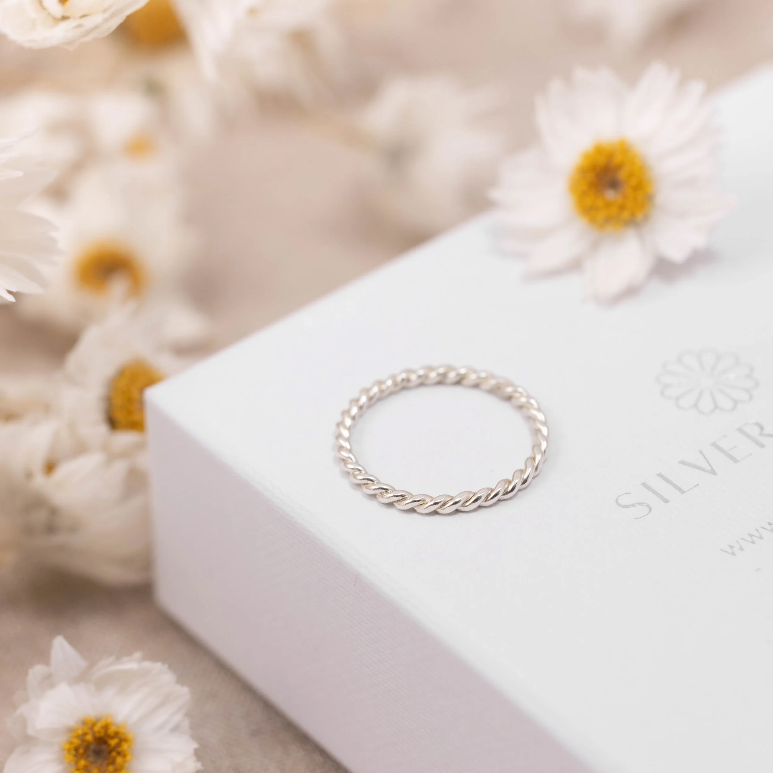 Delicate 9ct white gold twist stacking ring with a polished rope design, ideal for layering or wearing as a minimalist band.