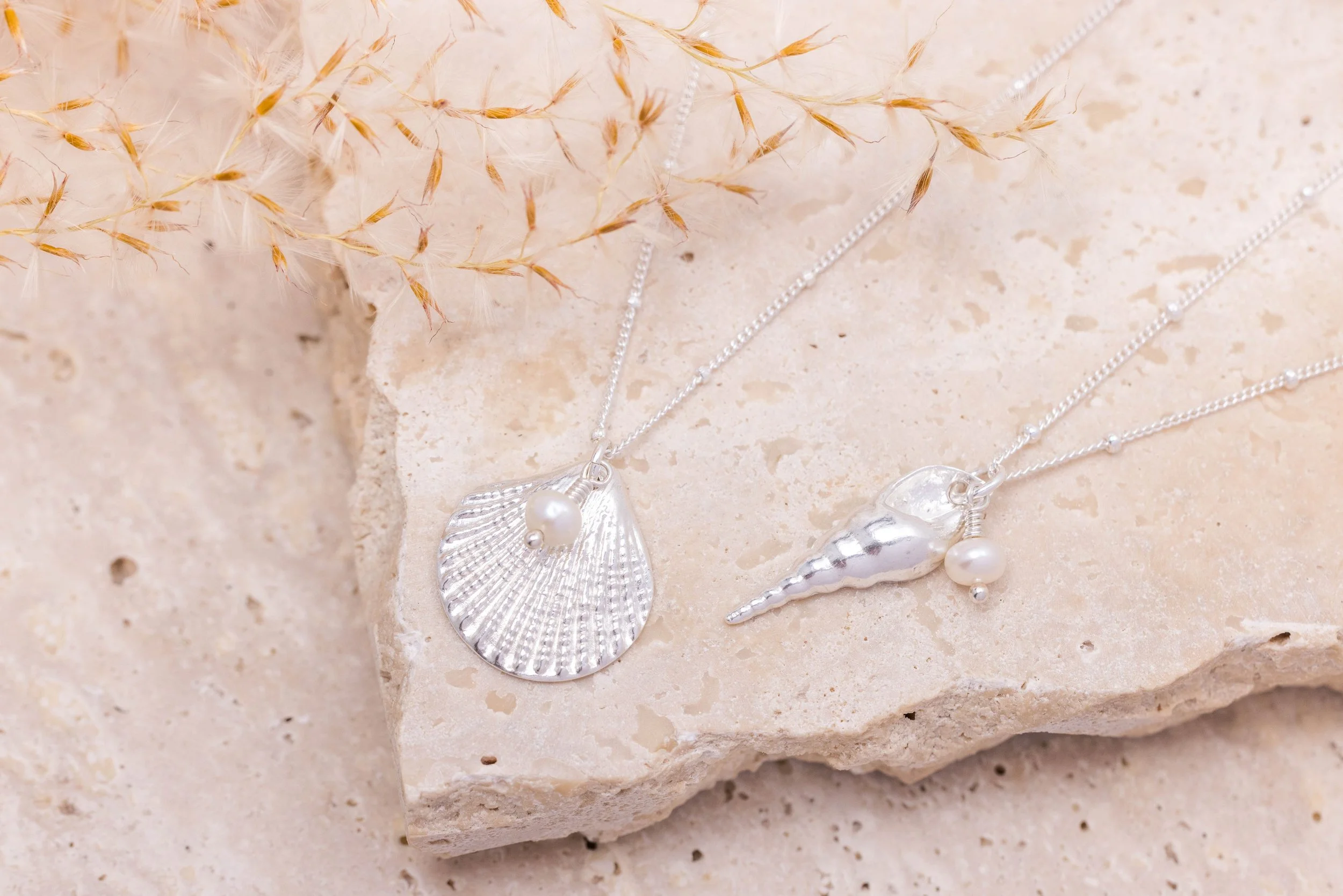 Sterling silver unicorn shell pendant necklace with a single round white pearl on a delicate chain.