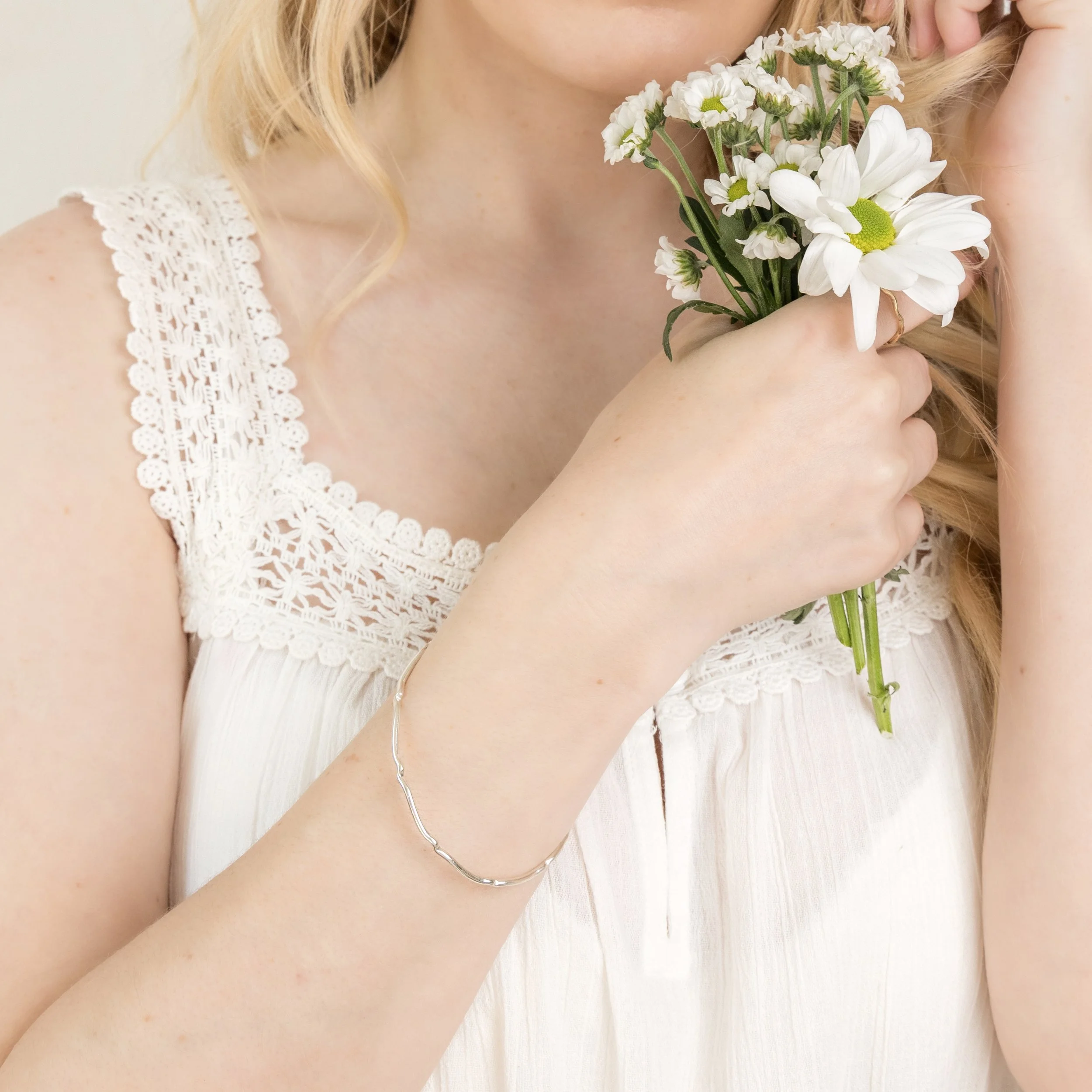 Sterling silver scalloped bangle with polished finish, featuring a wavy edge design for elegant stacking or standalone wear.