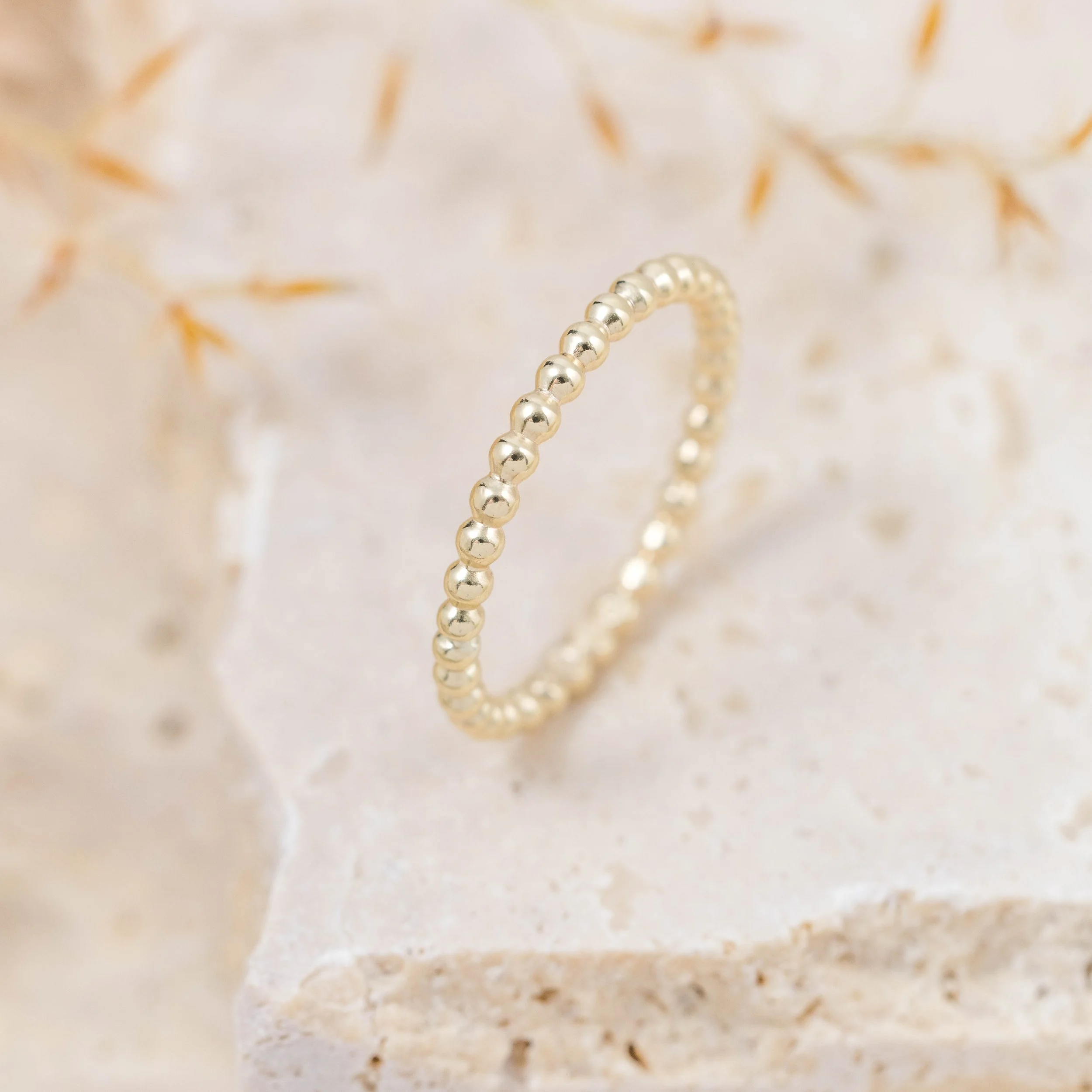 9ct yellow gold stacking ring with a delicate bobble design, featuring a polished finish and slender band for versatile wear.