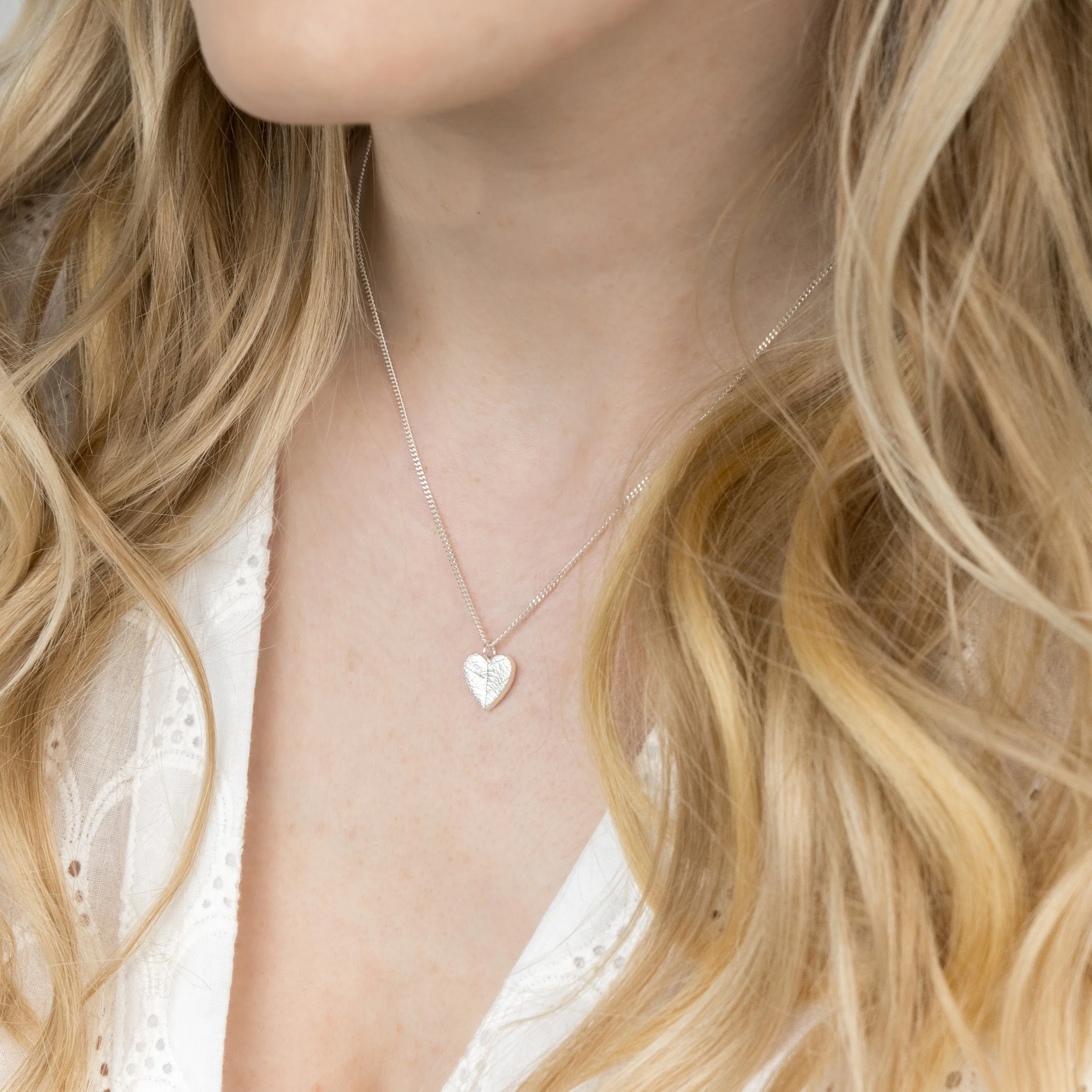 Handmade sterling silver heart pendant with delicate leaf vein texture on a fine silver chain necklace.