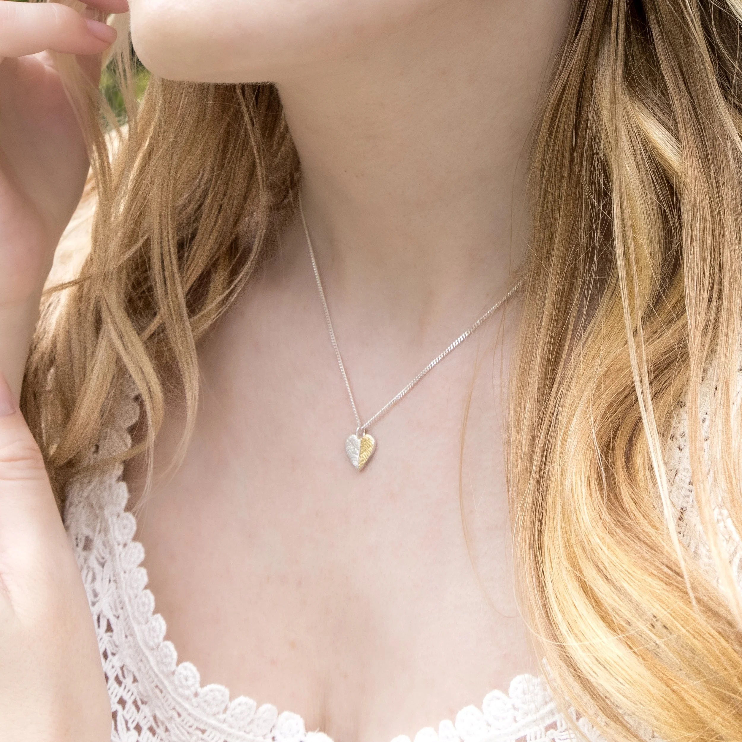 Gold and silver heart leaf pendant necklace with textured leaf pattern on a fine silver chain, handmade botanical jewellery.