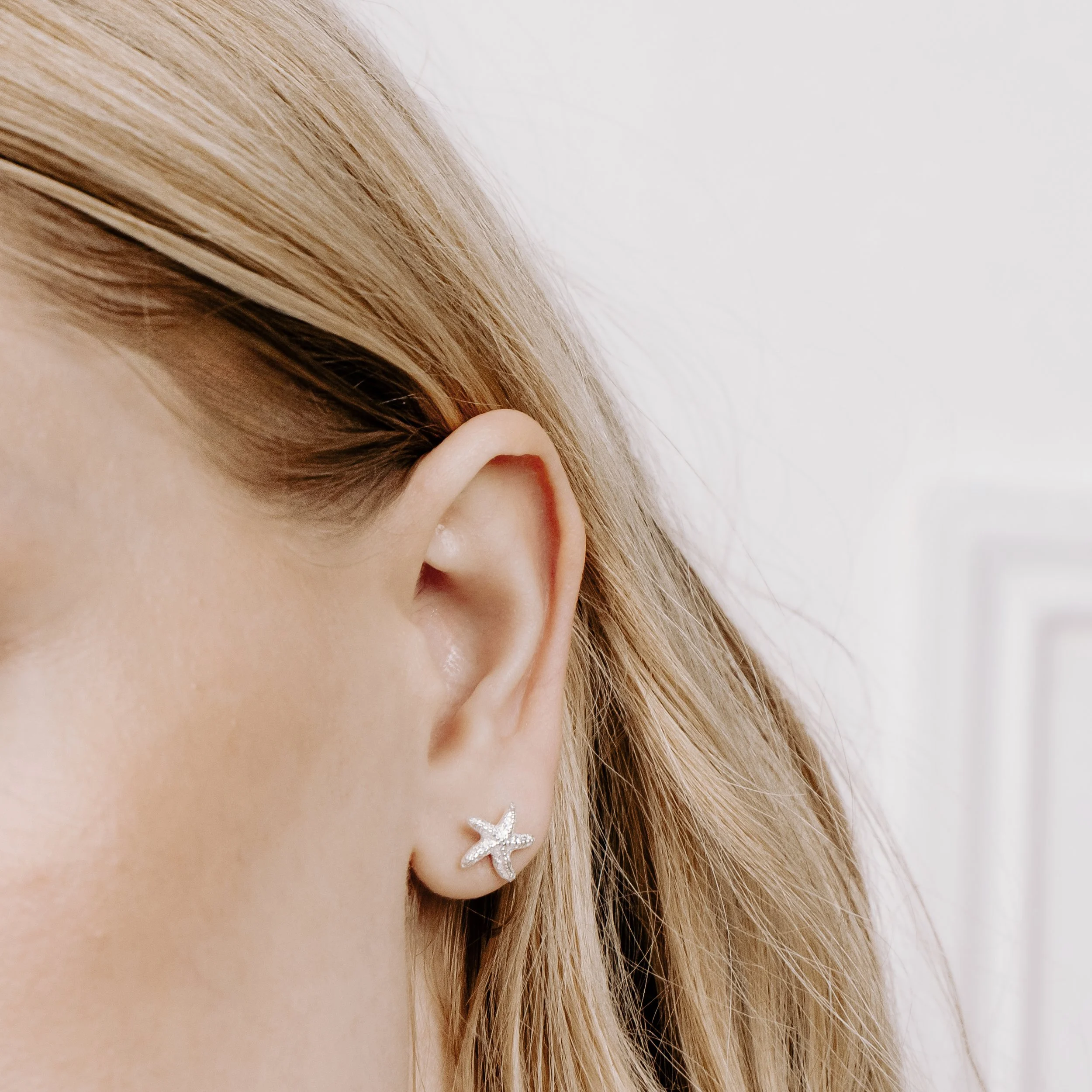Silver starfish stud earrings with textured detailing and polished finish, part of the Silver Daisy Coastal Collection.
