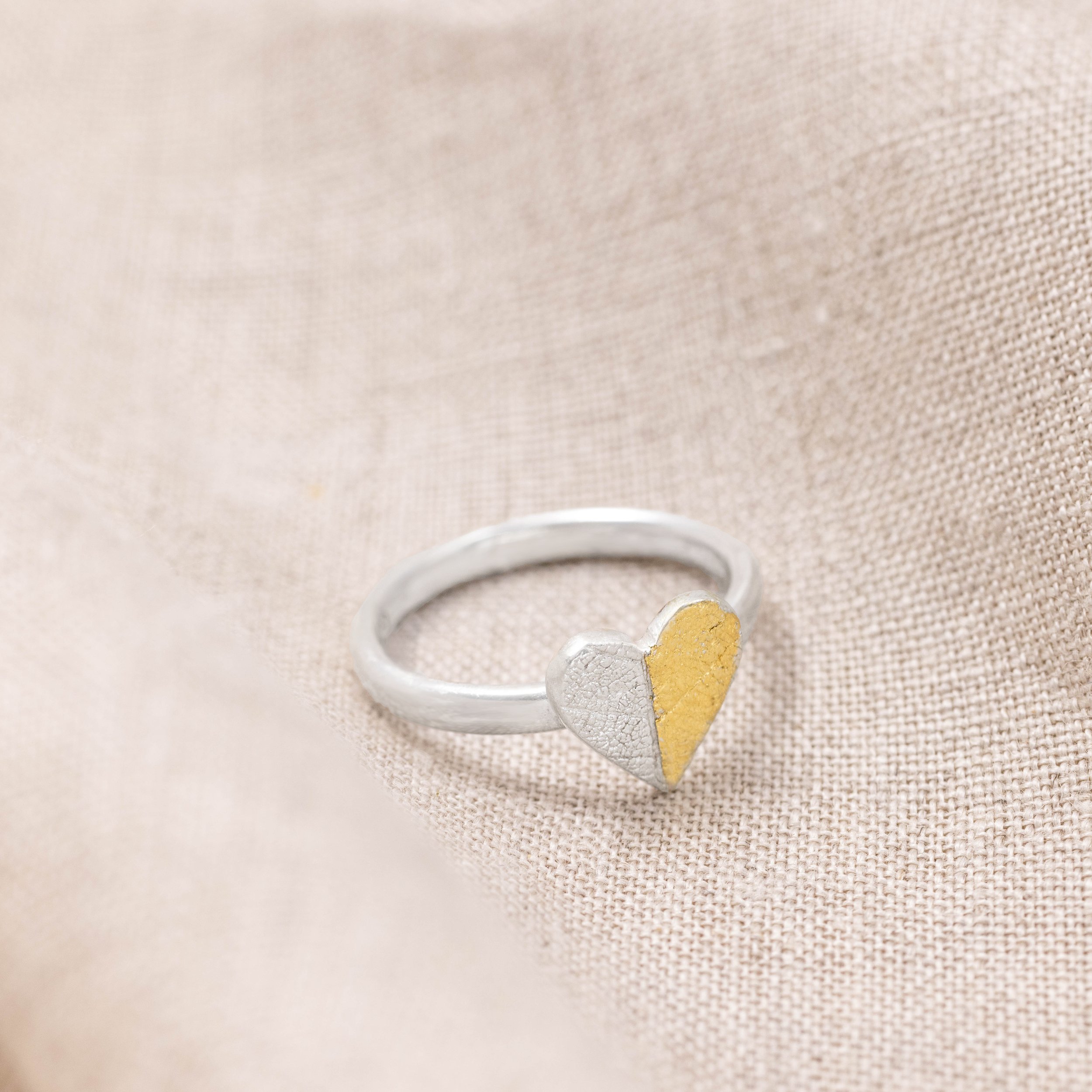 Sterling silver heart-shaped ring with textured leaf pattern and 24ct gold Keum Boo detailing on a polished band.