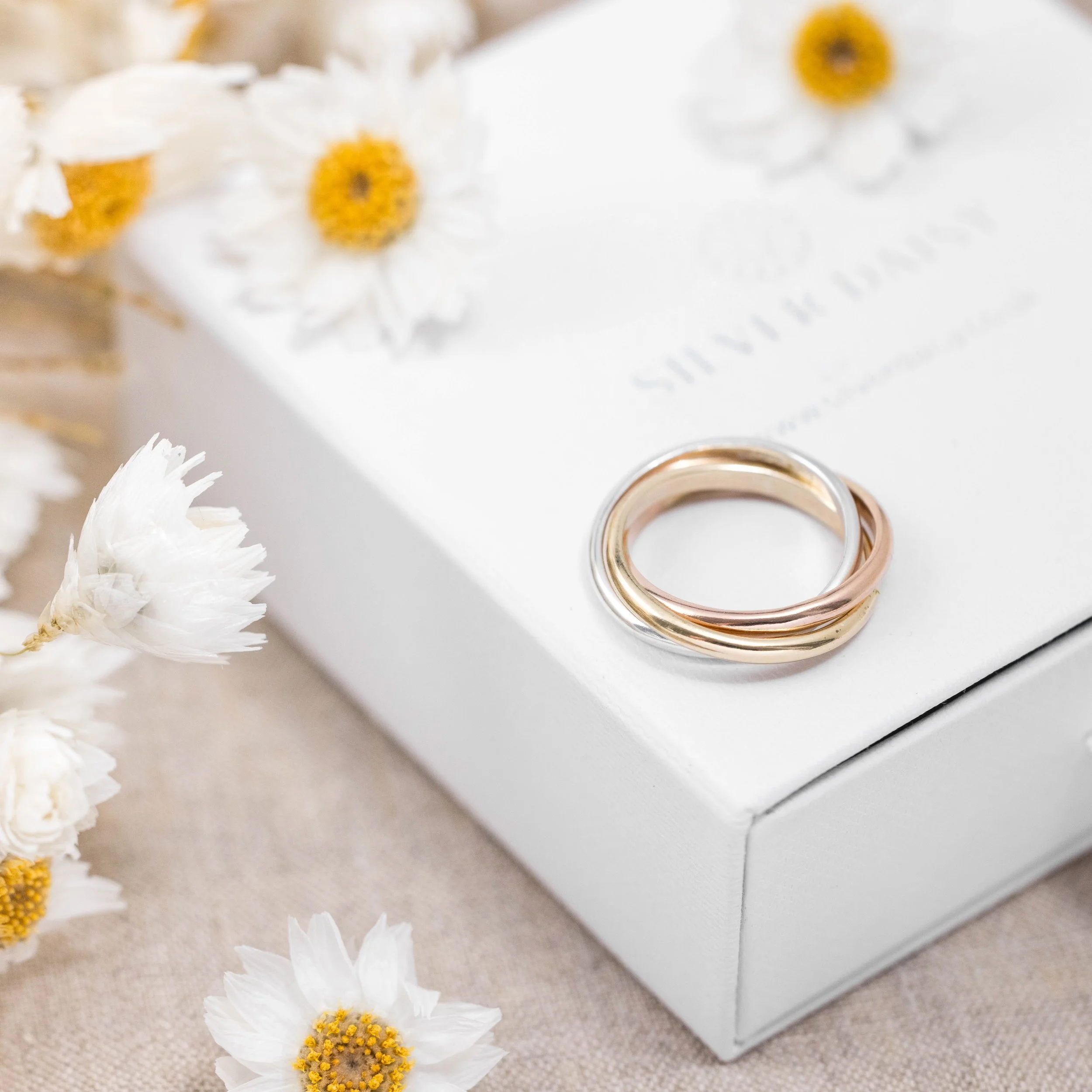 9ct gold tricolour trinity ring featuring interlocking yellow, white, and rose gold bands with a polished finish.