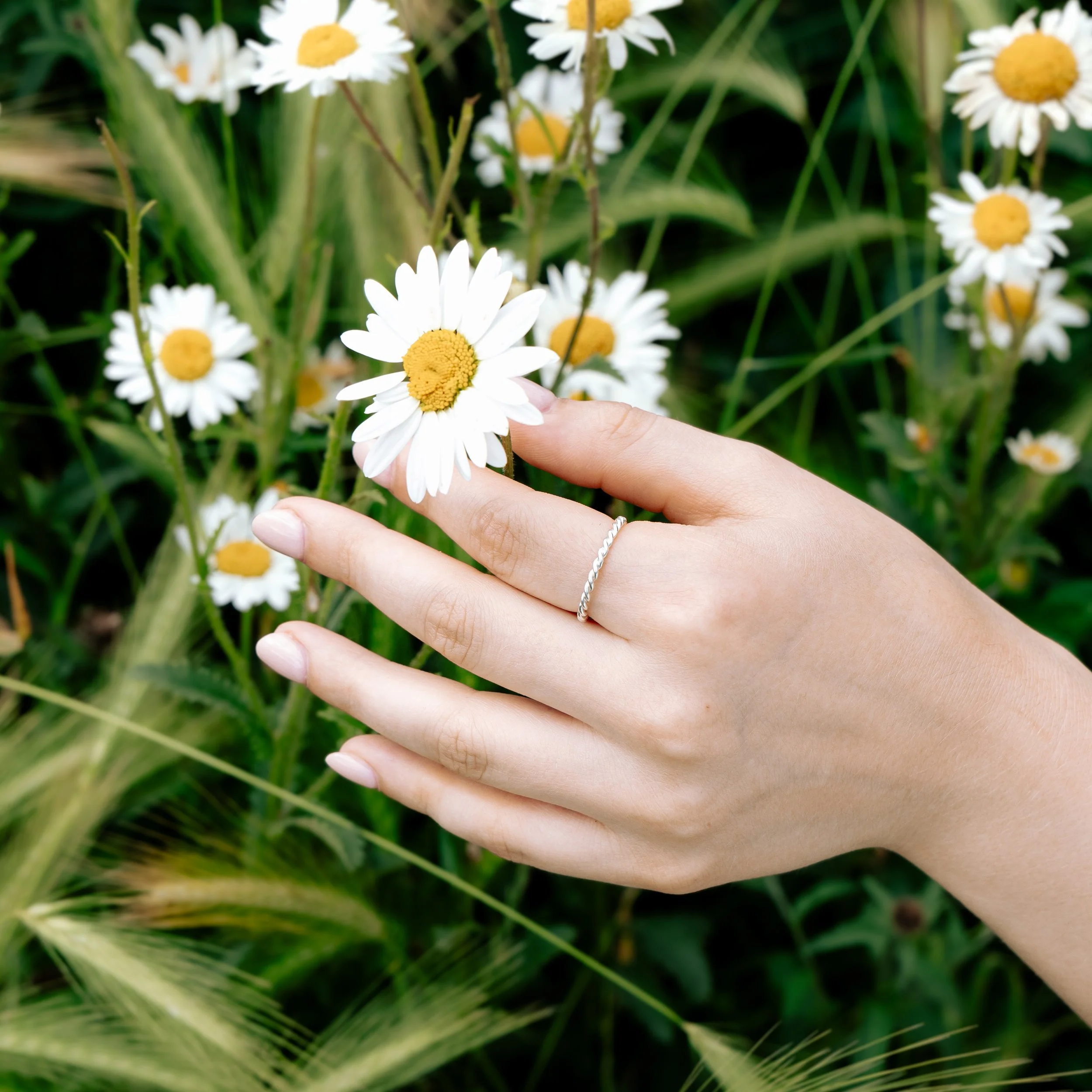 Polished sterling silver twist stacking ring with a delicate rope design, ideal for layering or wearing alone.