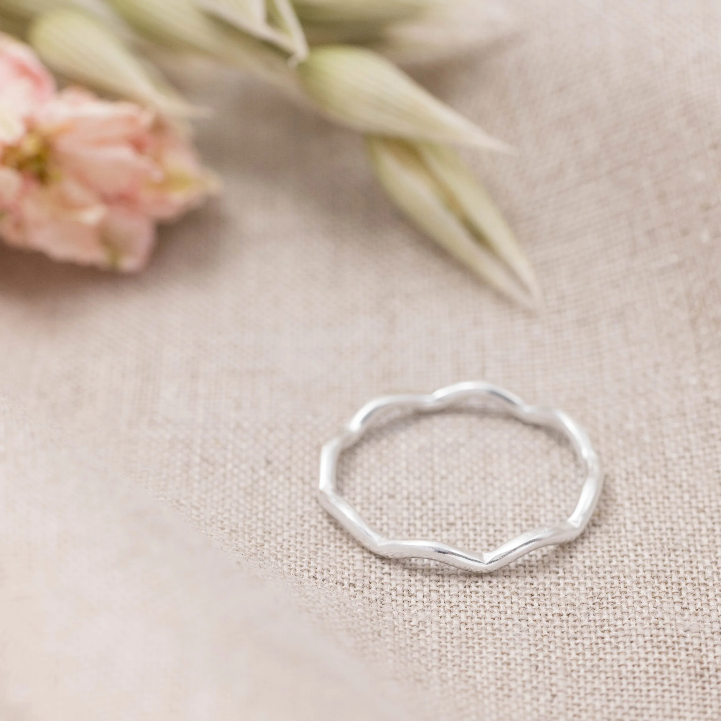 Sterling silver stacking ring with a smooth wave design and polished finish, ideal for layering in minimalist jewellery styles.