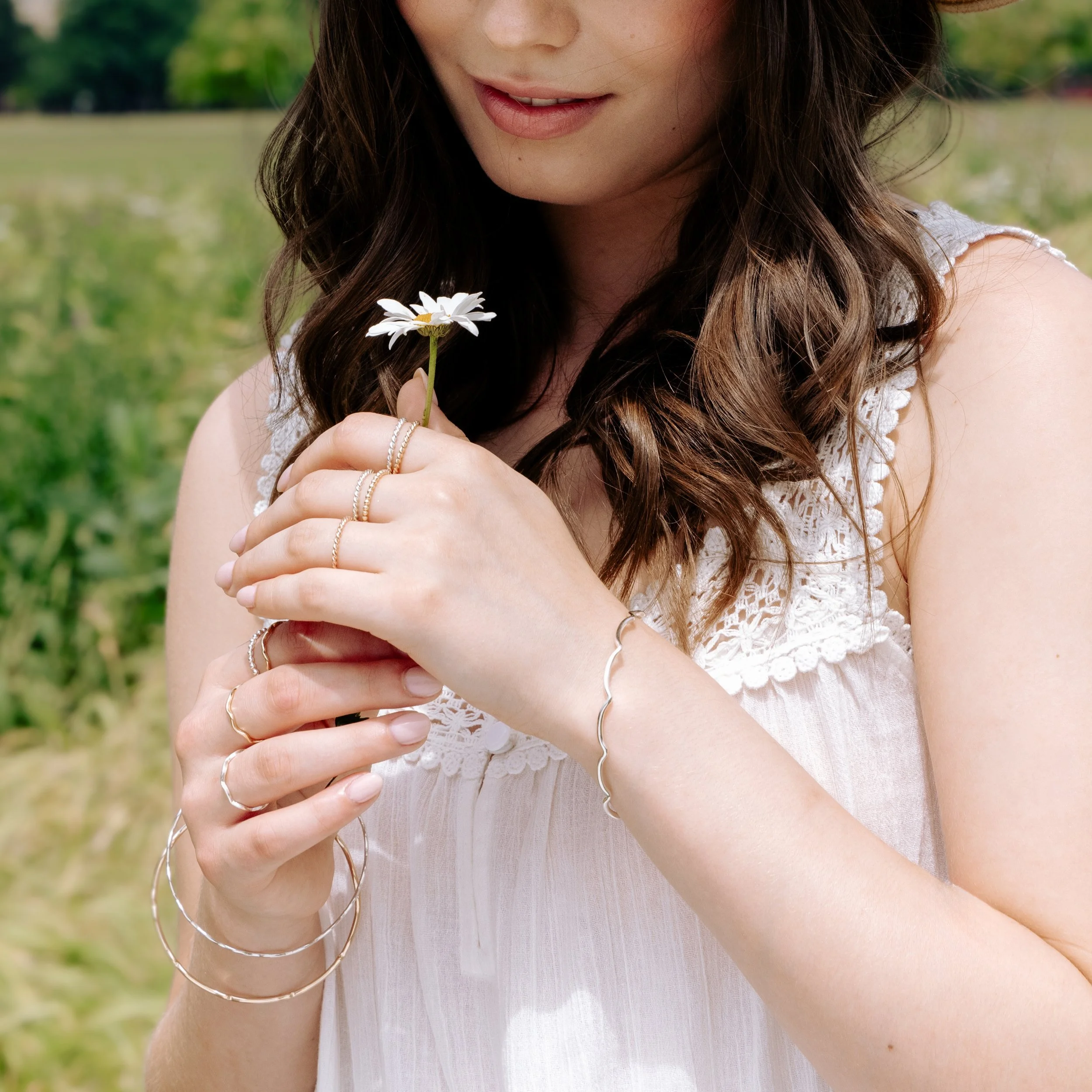 Slim sterling silver stacking bangle with a polished wave design, perfect for layering in a modern minimalist style or simply worn alone.