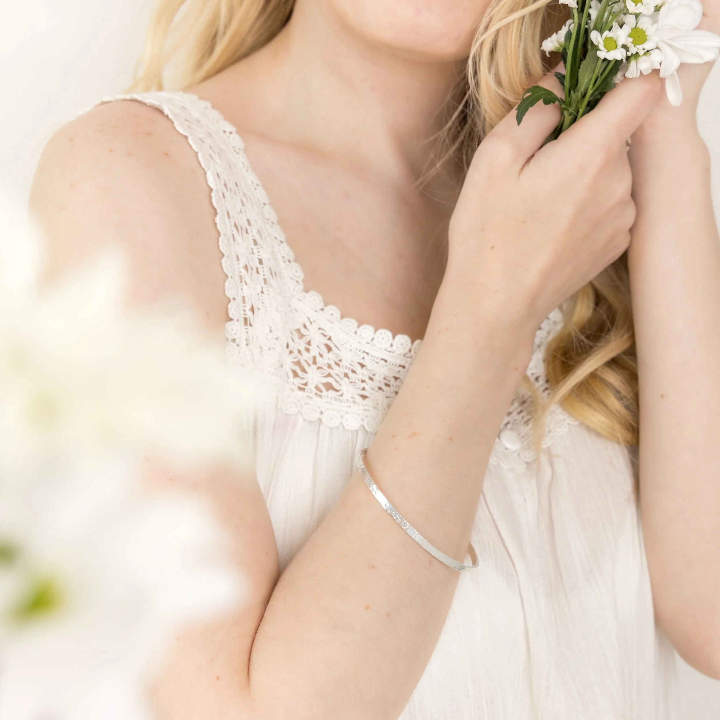 Sterling silver stacking bangle with a hammered dimple texture, polished finish, and minimalist contemporary design.