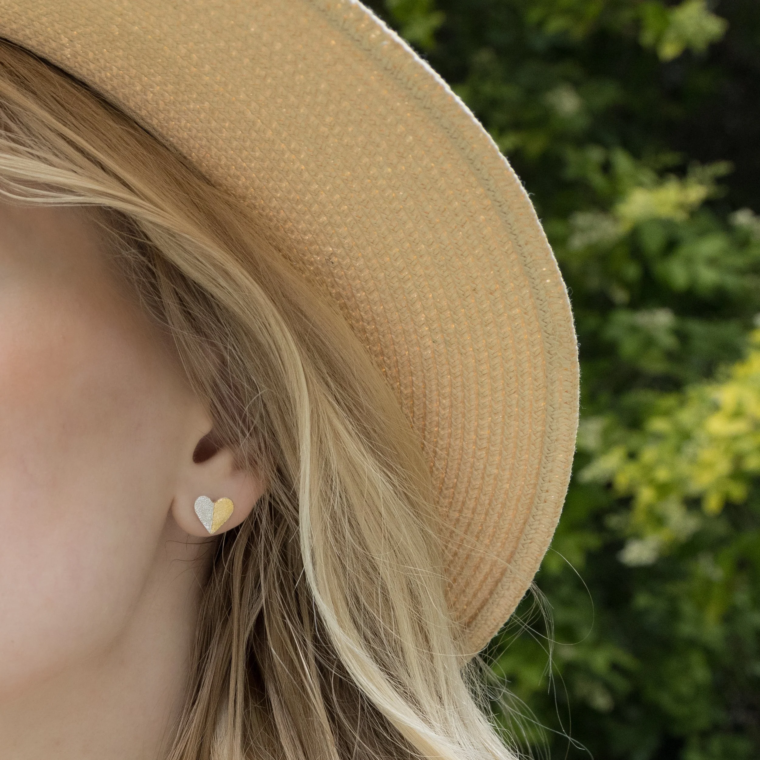 Sterling silver heart-shaped stud earrings with textured leaf pattern and gold keum-boo accents.
