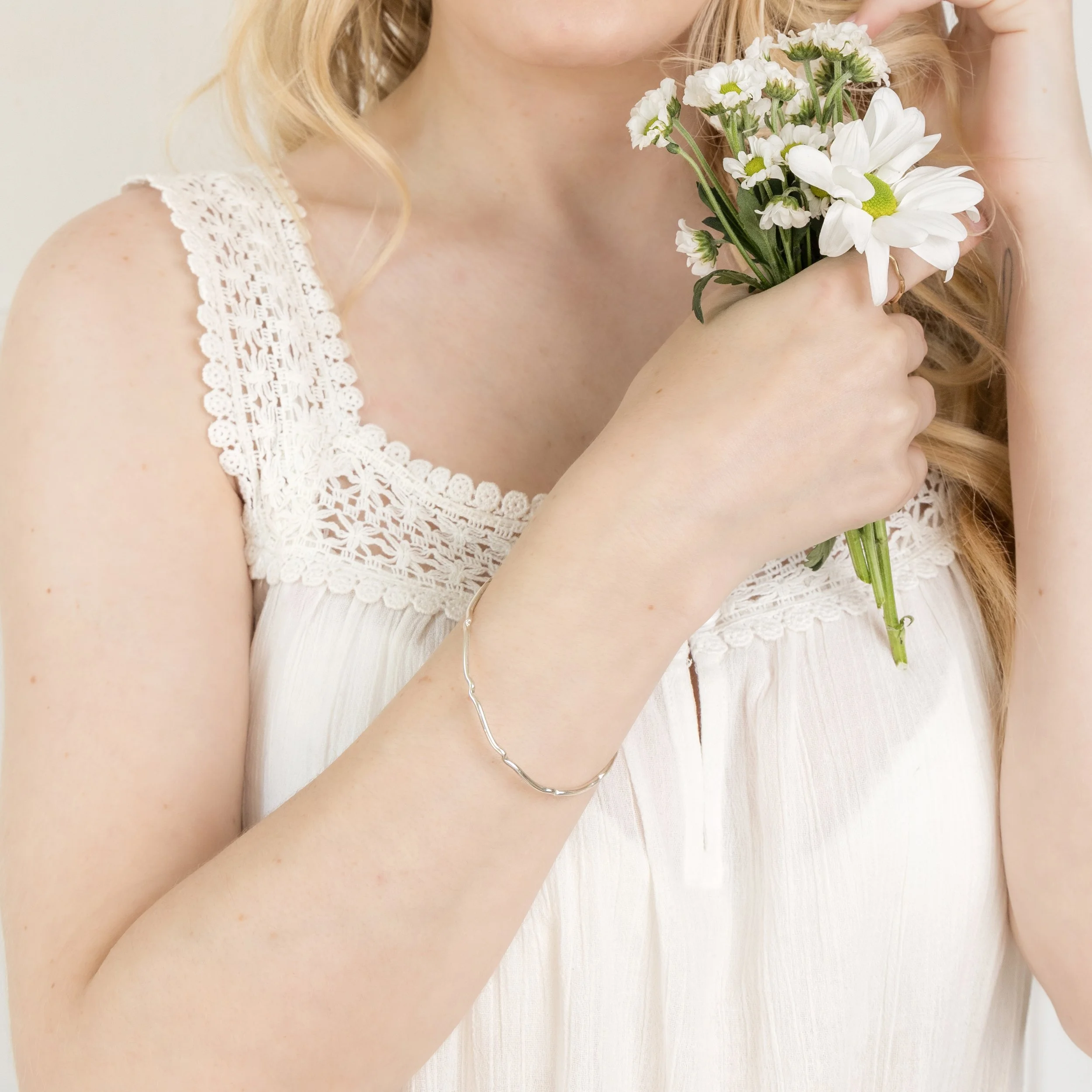Sterling silver scalloped bangle with polished finish, featuring a wavy edge design for elegant stacking or standalone wear.