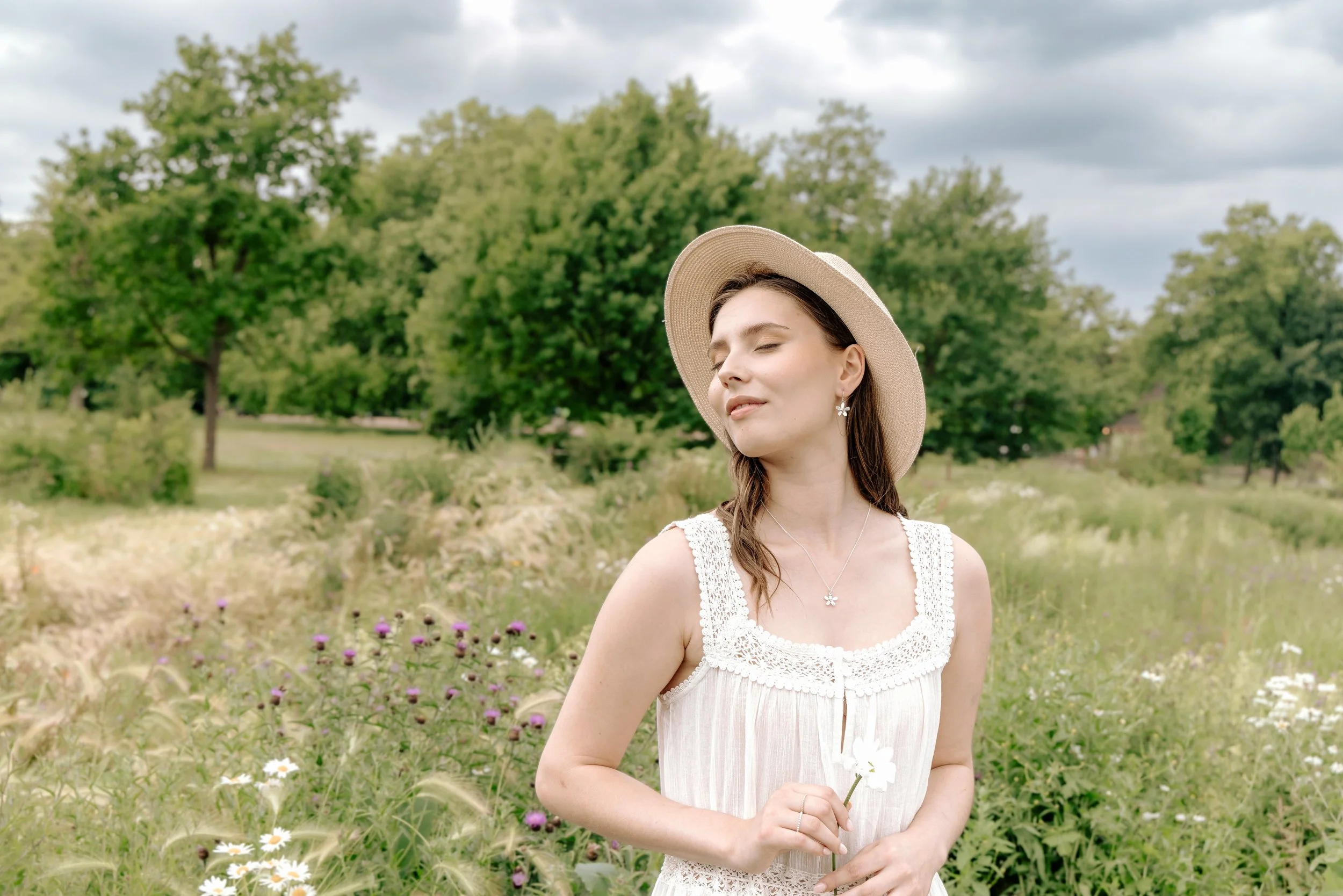 Sterling silver daisy pendant necklace with polished petals and a 9ct gold stamen on a delicate silver chain.