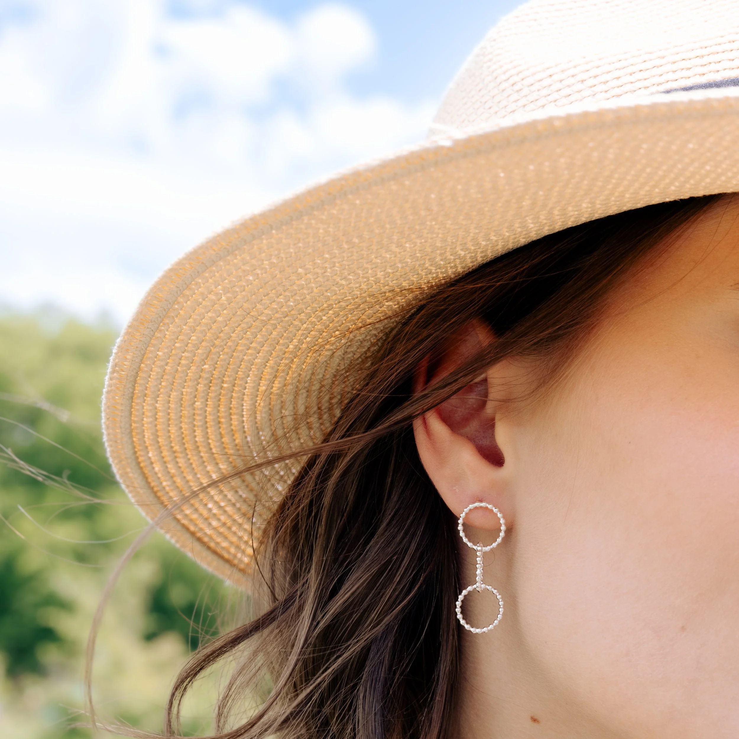 Sterling silver multi-hoop earrings with polished bead accents and textured loops arranged in a layered, contemporary design.