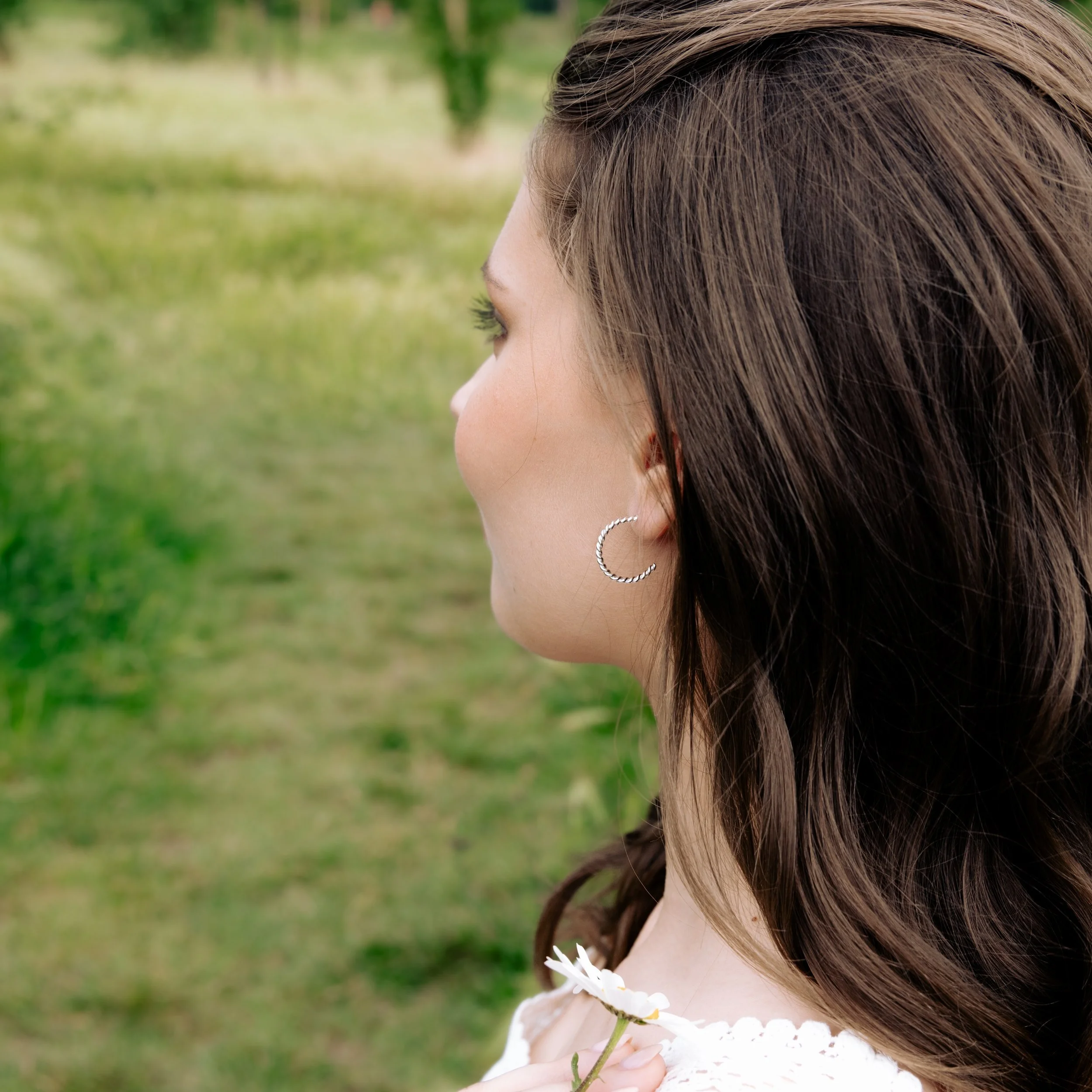 Polished sterling silver twist hoop earrings with a textured spiral design, lightweight and elegant for everyday wear.