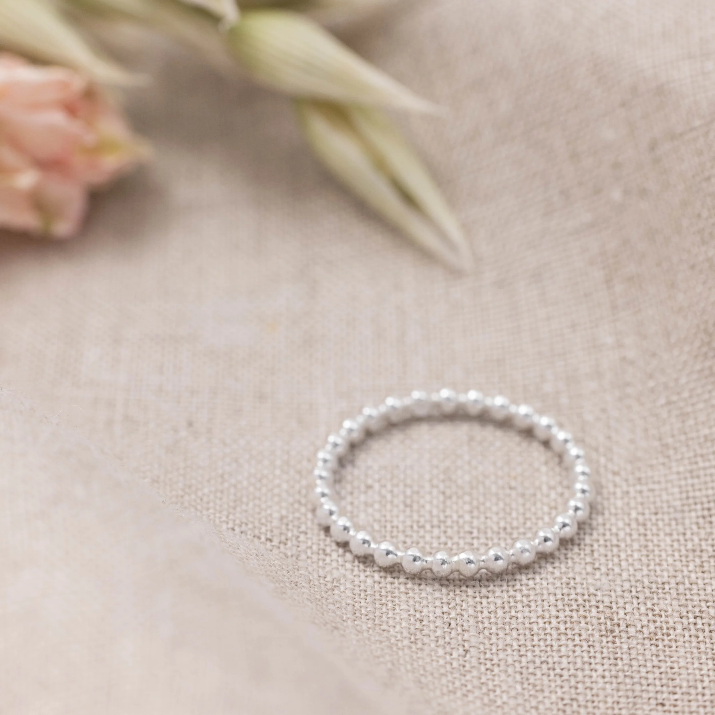 Sterling silver bobble stacking ring with polished beaded band, minimalist design ideal for layering or everyday wear.