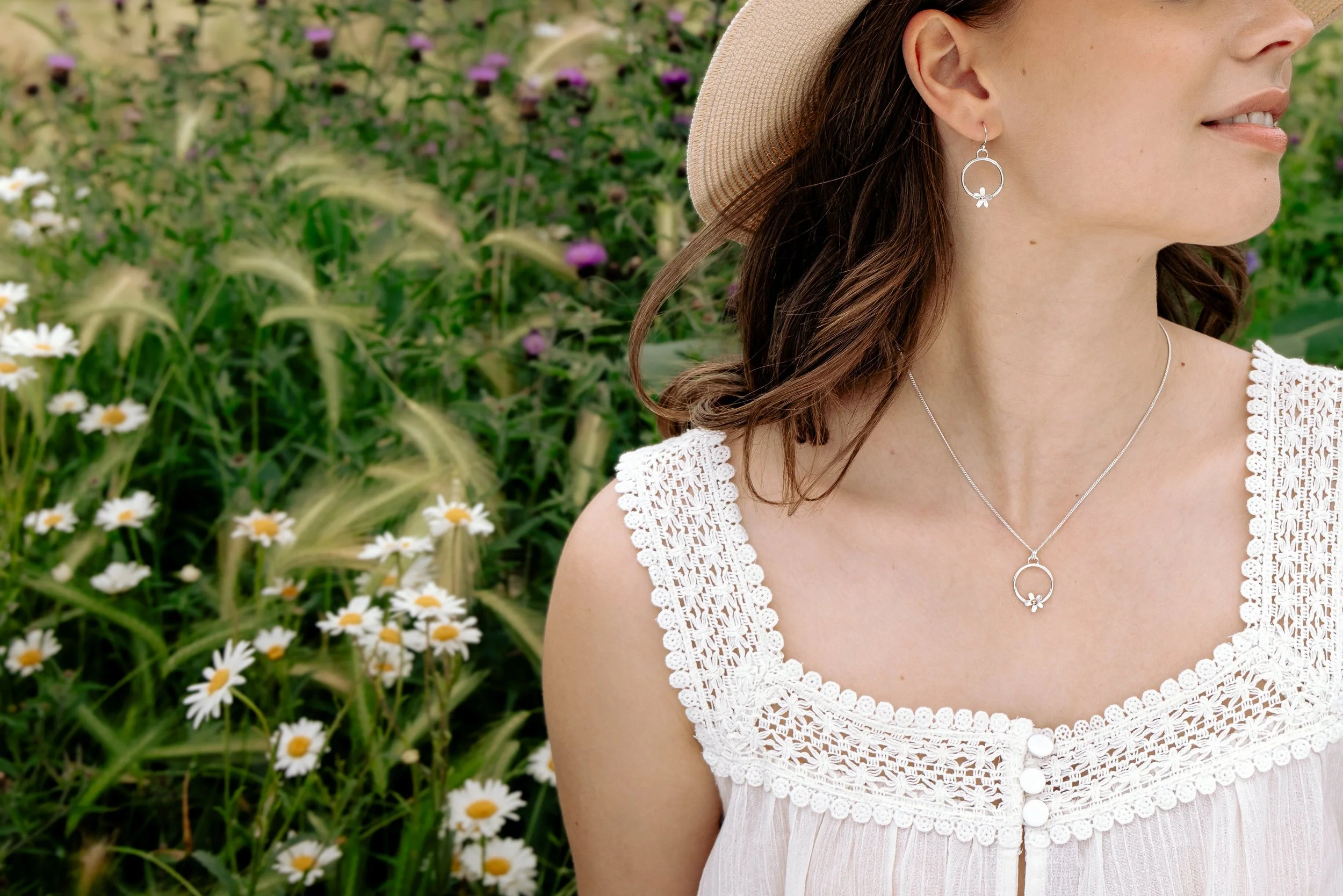 Sterling silver hoop earrings with delicate daisy flower charms, featuring 9ct gold stamen, and a polished and lightweight finish.