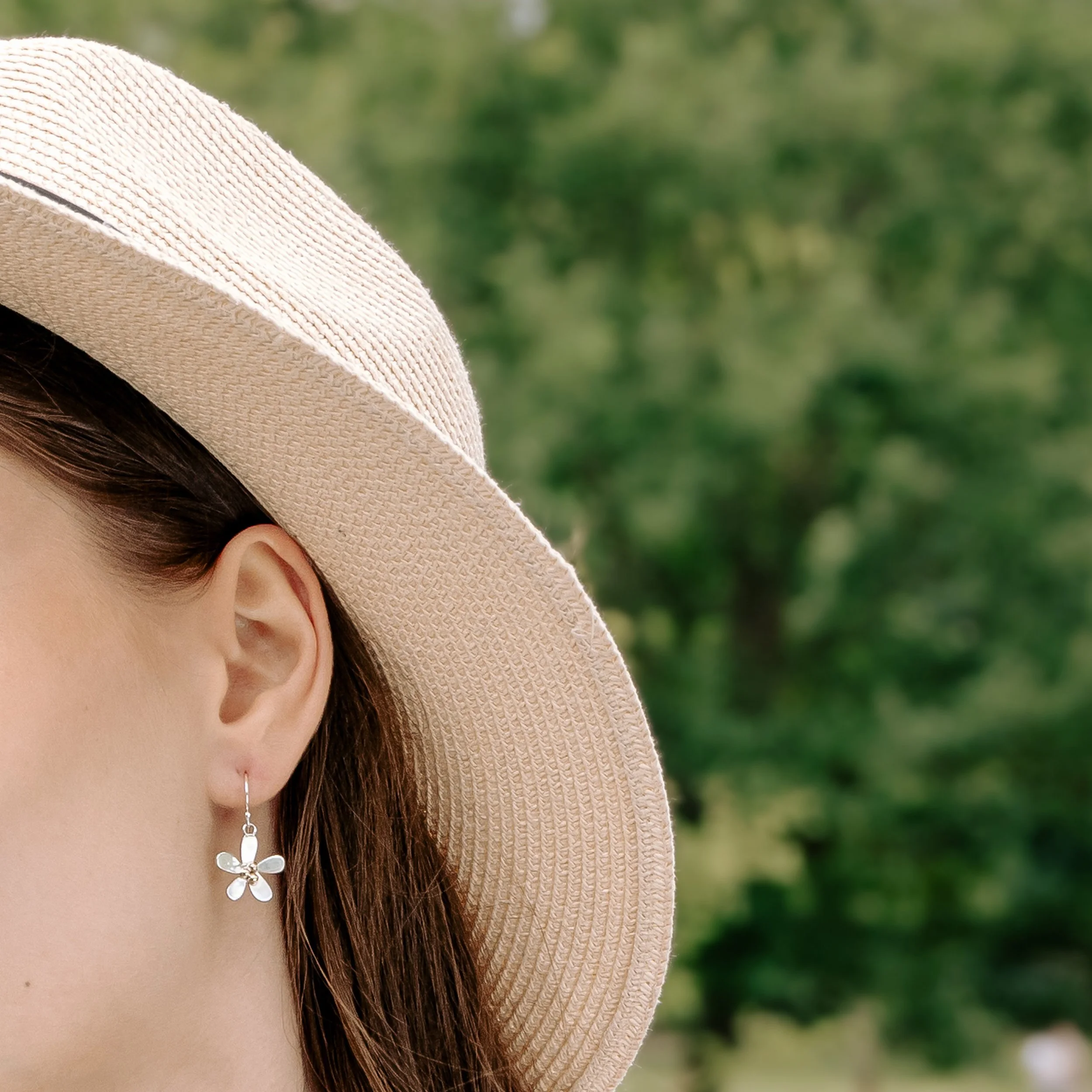 Sterling silver daisy dangle earrings with polished petals and contrasting 9ct gold stamen.