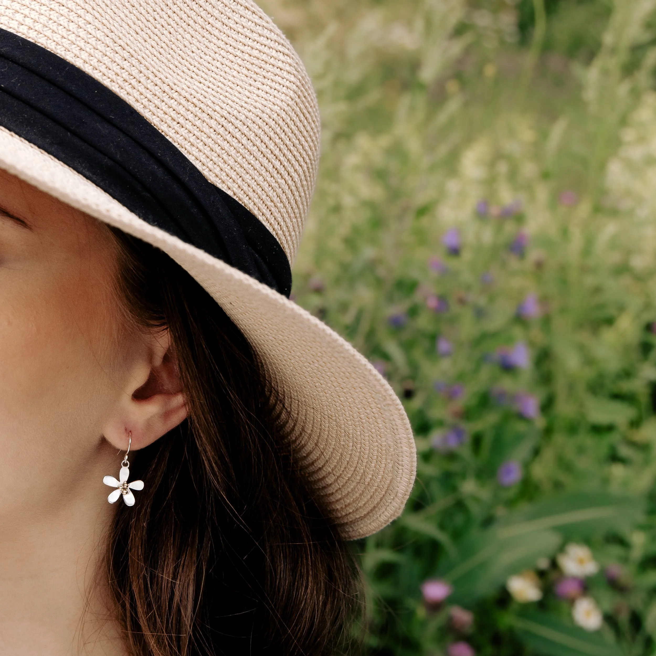 Sterling silver daisy dangle earrings with polished petals and contrasting 9ct gold stamen.