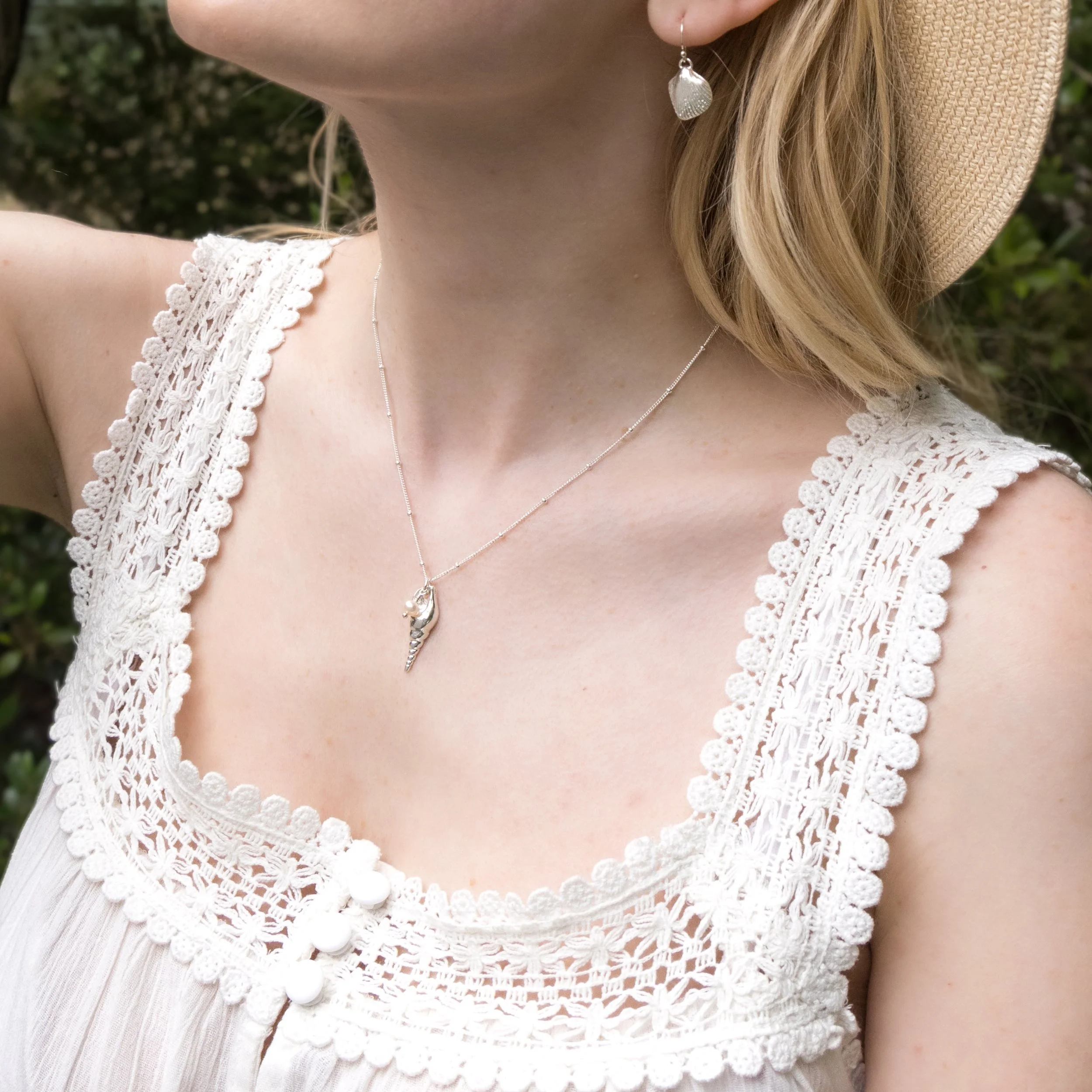 Sterling silver unicorn shell pendant necklace with a single round white pearl on a delicate chain.