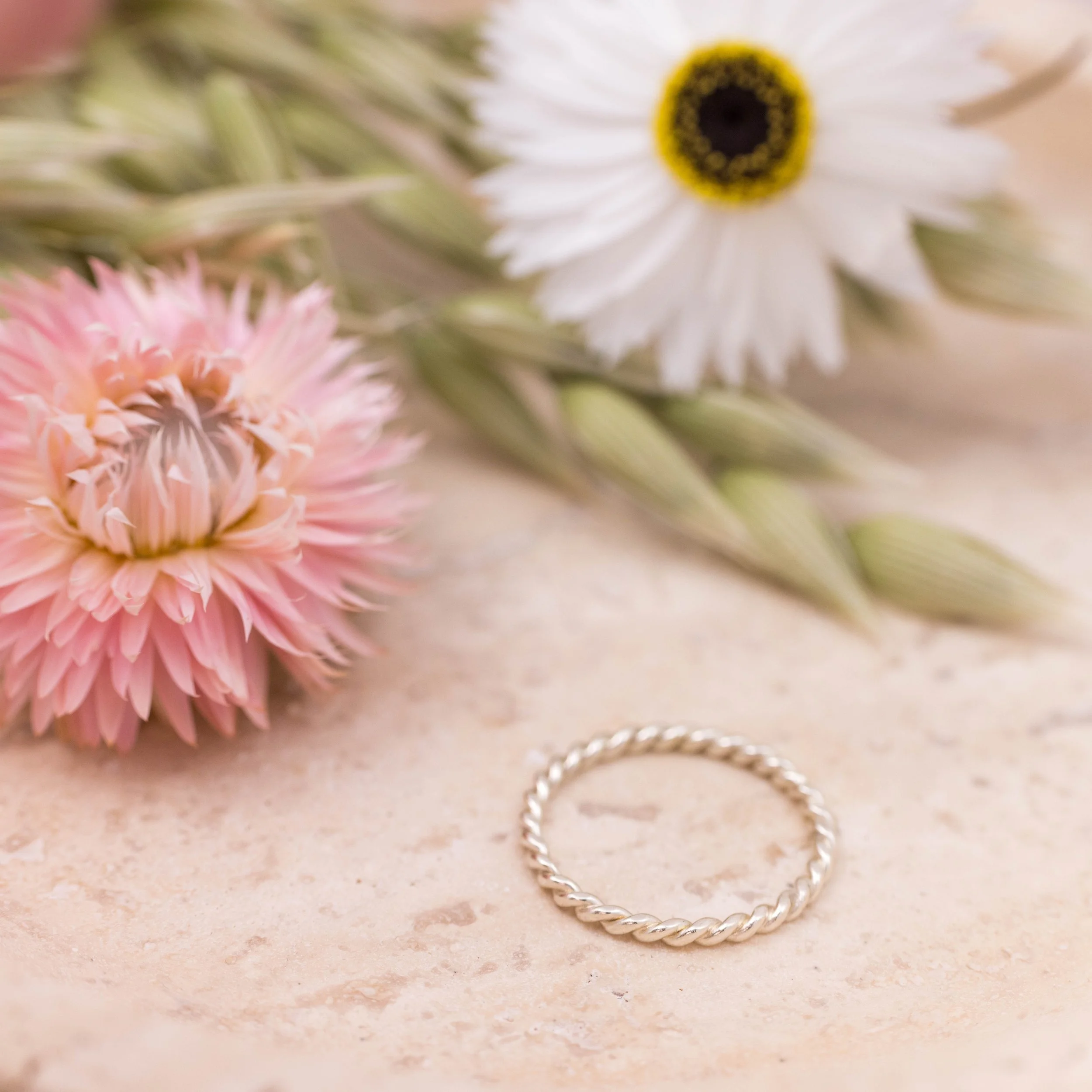 Delicate 9ct white gold twist stacking ring with a polished rope design, ideal for layering or wearing as a minimalist band.