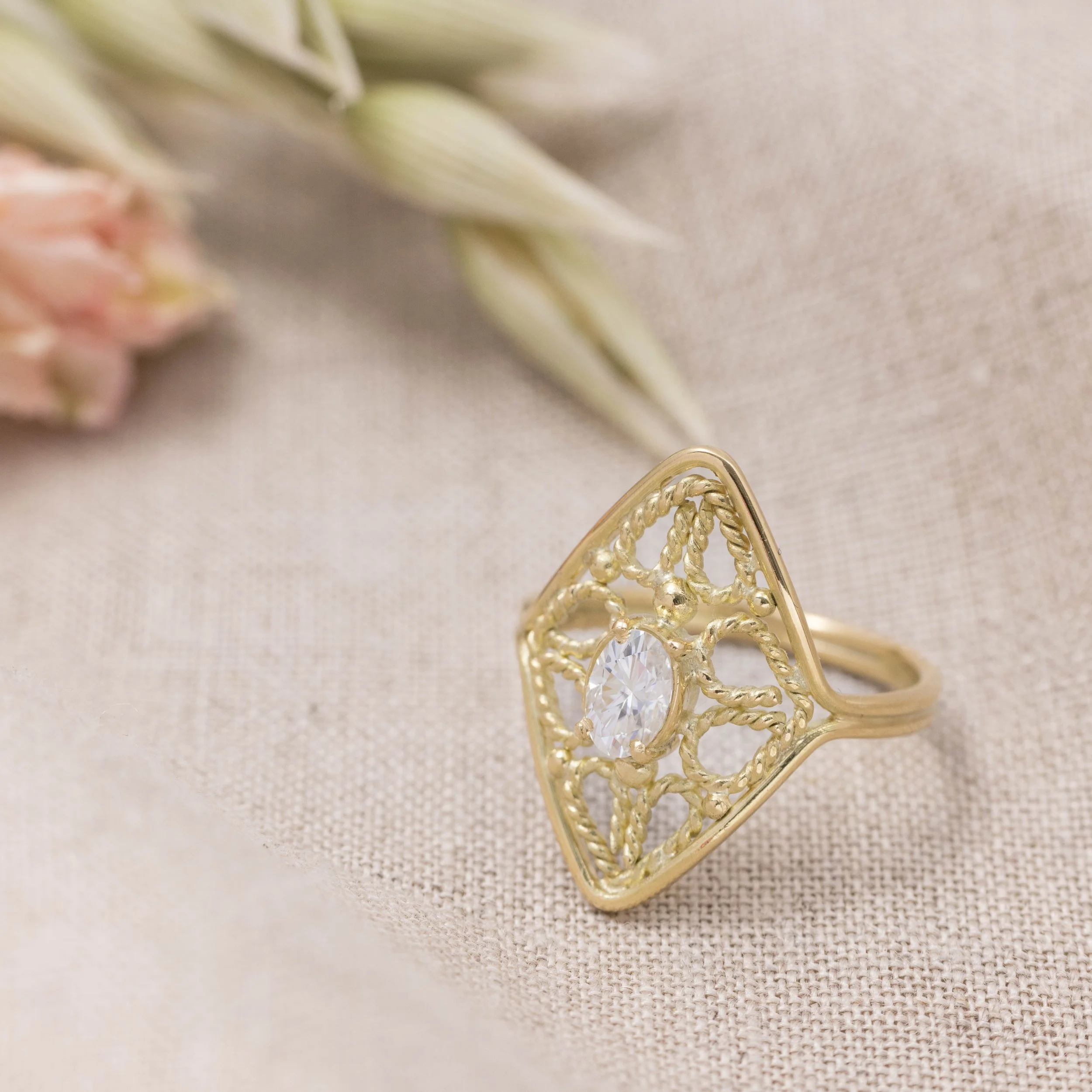 18ct yellow gold filigree ring with oval brilliant-cut moissanite centre stone and intricate vintage-inspired detailing.