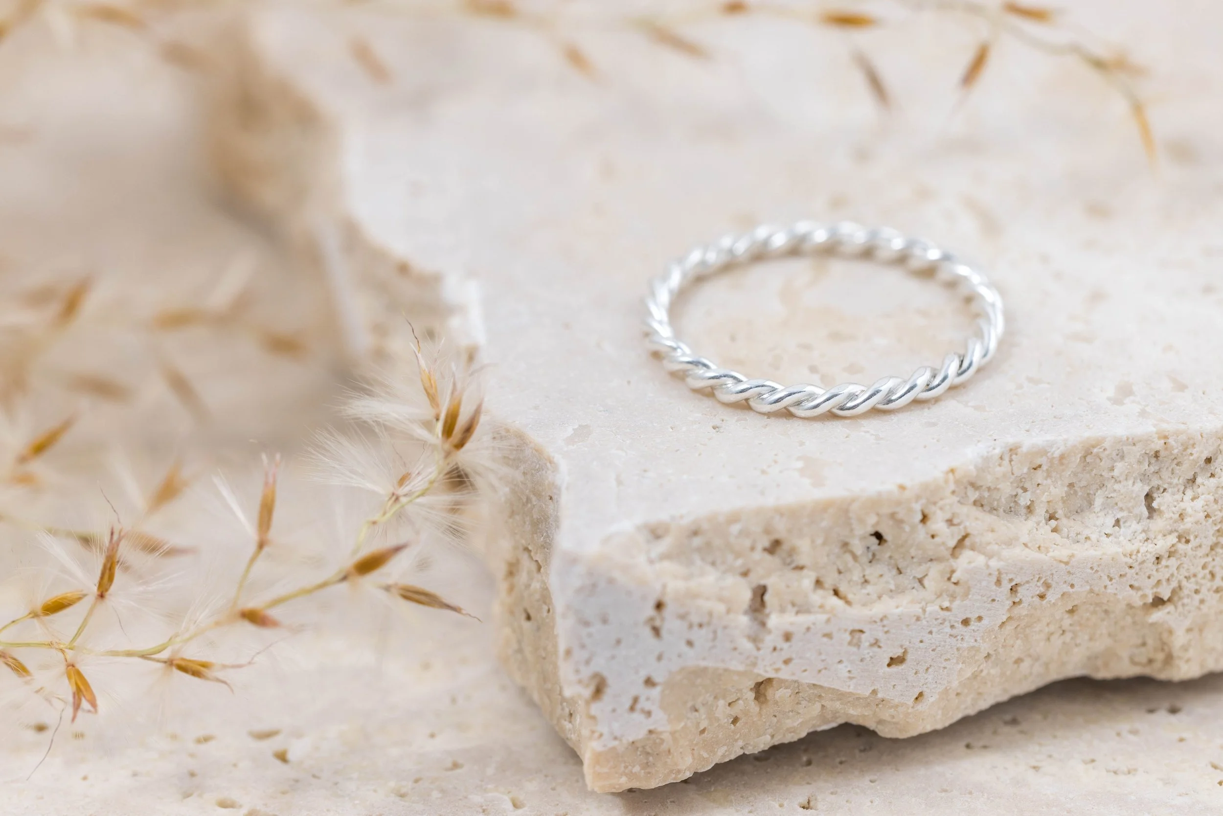 Polished sterling silver twist stacking ring with a delicate rope design, ideal for layering or wearing alone.