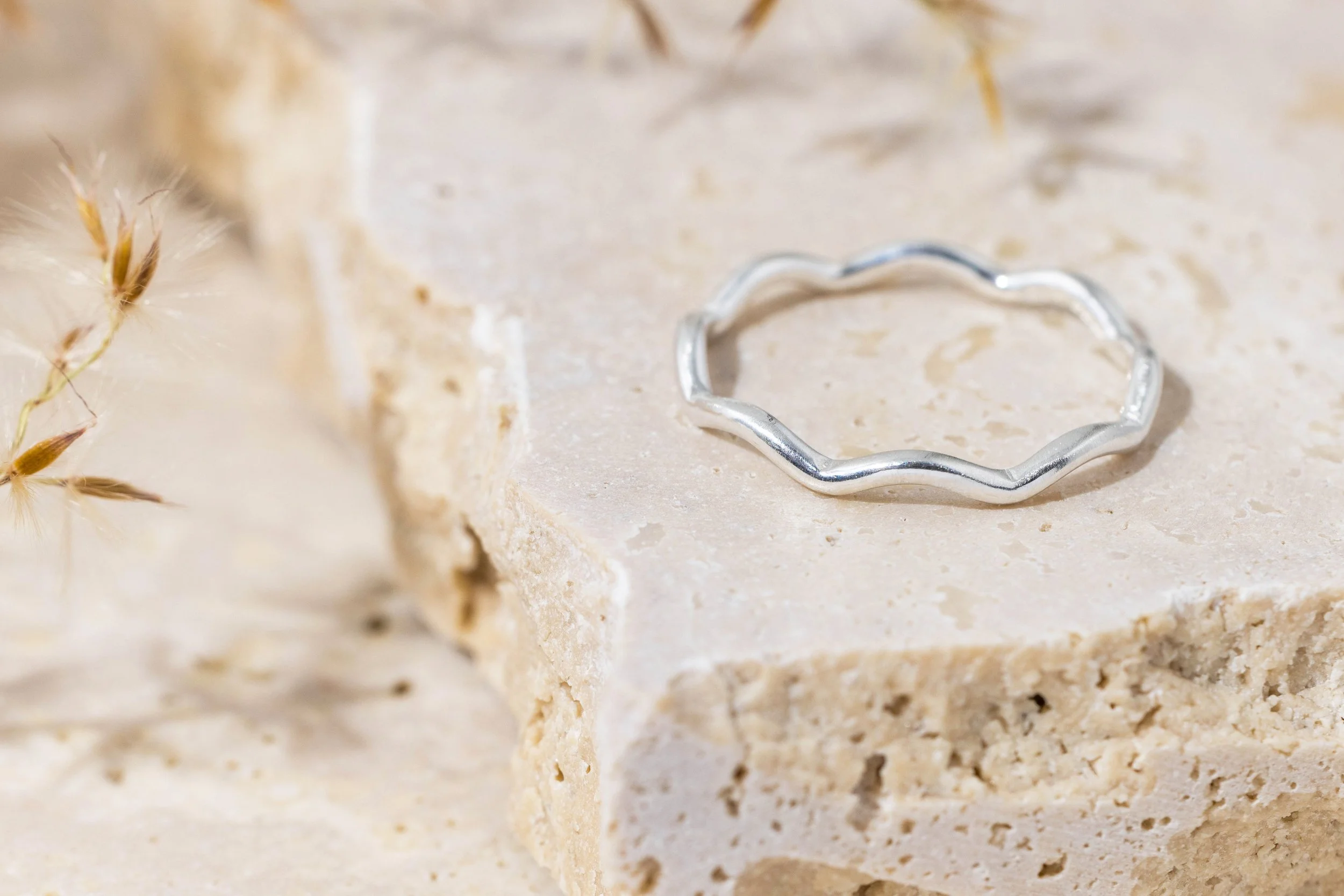 Sterling silver stacking ring with a smooth wave design and polished finish, ideal for layering in minimalist jewellery styles.