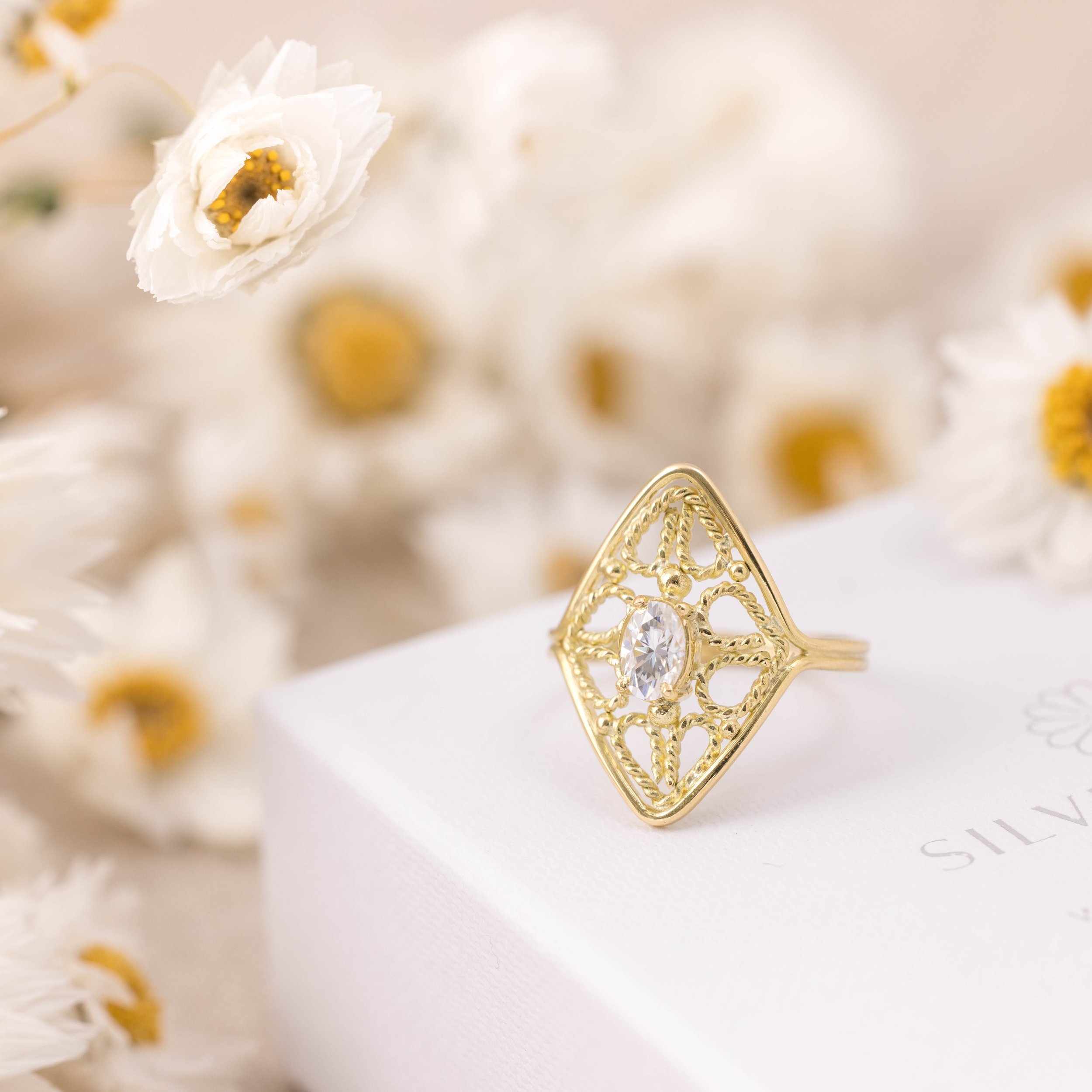 18ct yellow gold filigree ring with oval brilliant-cut moissanite centre stone and intricate vintage-inspired detailing.