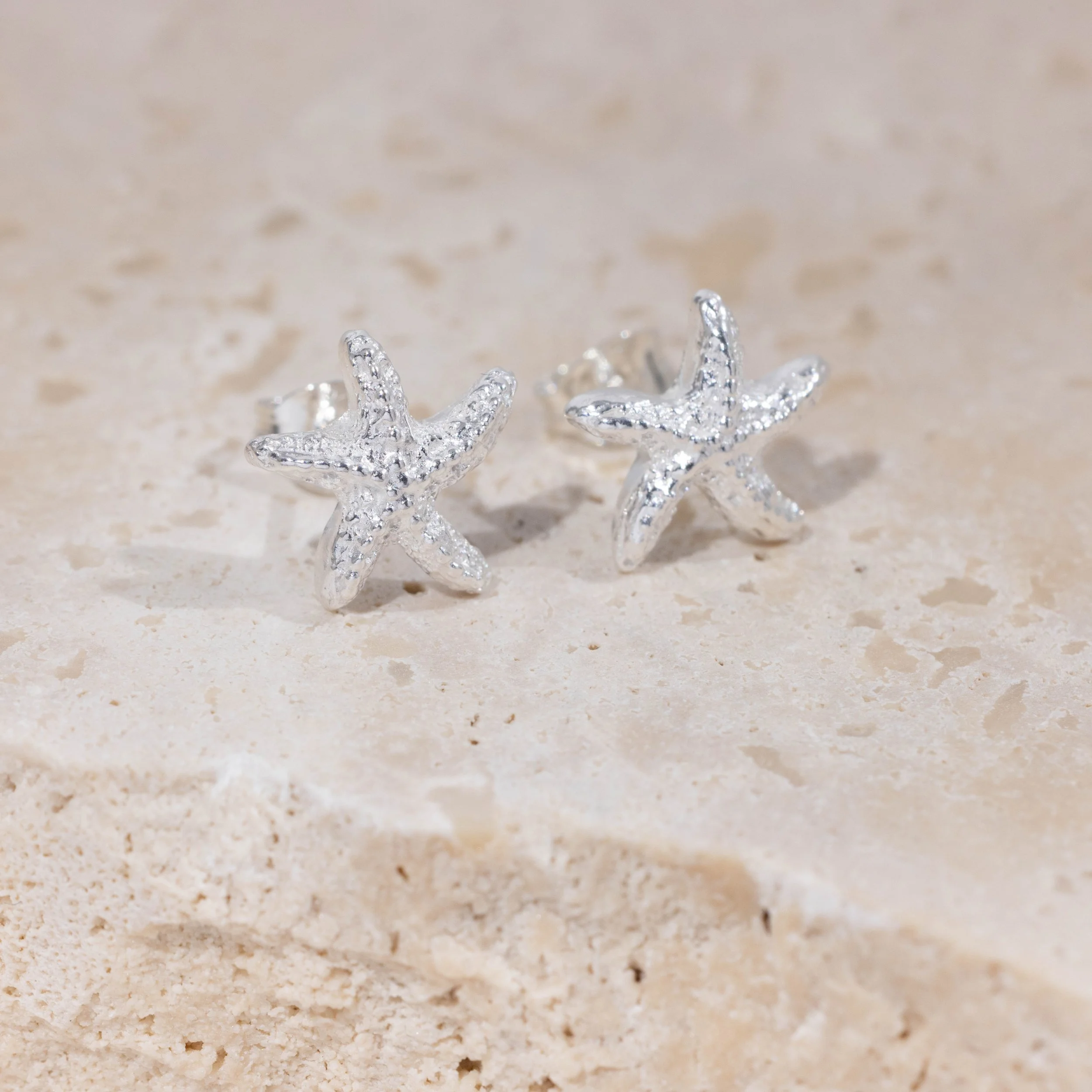 Silver starfish stud earrings with textured detailing and polished finish, part of the Silver Daisy Coastal Collection.