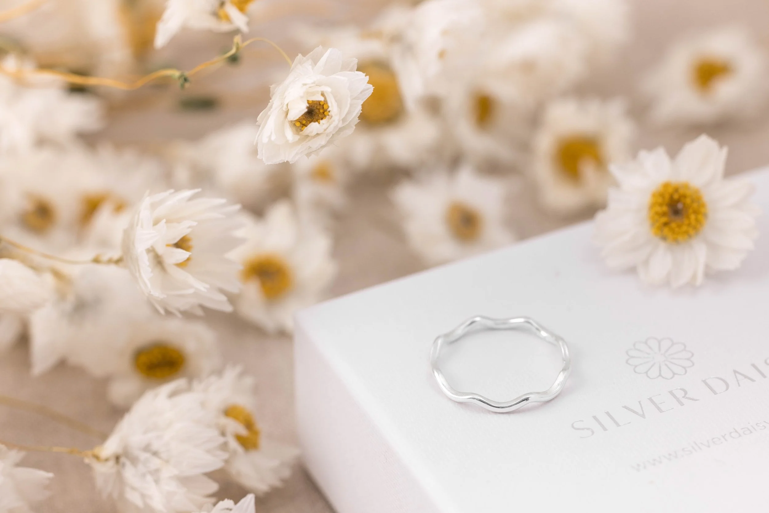 Sterling silver stacking ring with a smooth wave design and polished finish, ideal for layering in minimalist jewellery styles.