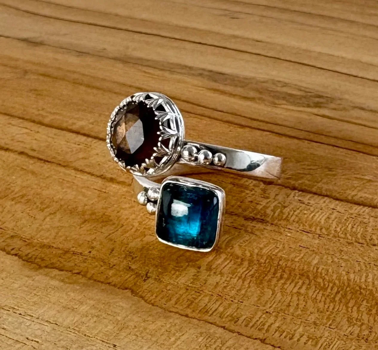 140 euro. Kyaniet en roosgeslepen Rook Quartz. Maat 17 3/4. 6 asymmetrisch geplaatste balletjes op ringband. Zilver en fijnzilver.