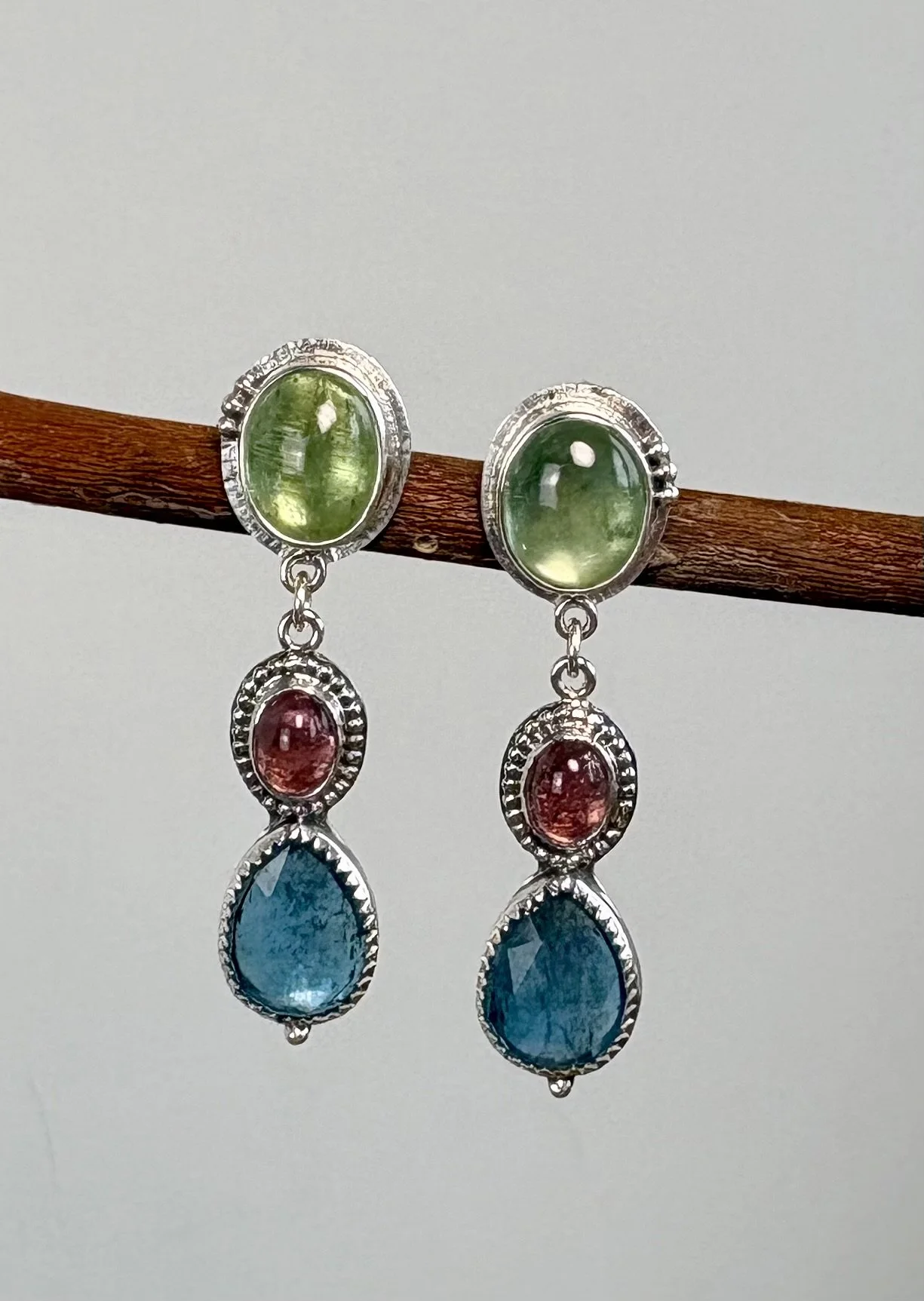 215 euro. Groene en blauwe Kyaniet en roze Toermalijn. Maat 40 x 12 mm. Zilver en fijnzilver