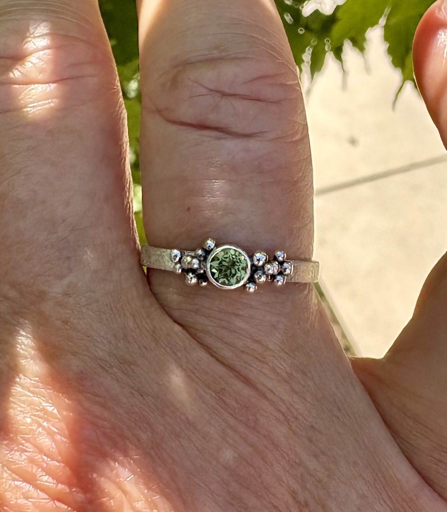 VERKOCHT. Peridoot. Granules op gematteerde ringband. Maat 17 1/2, zilver en fijnzilver