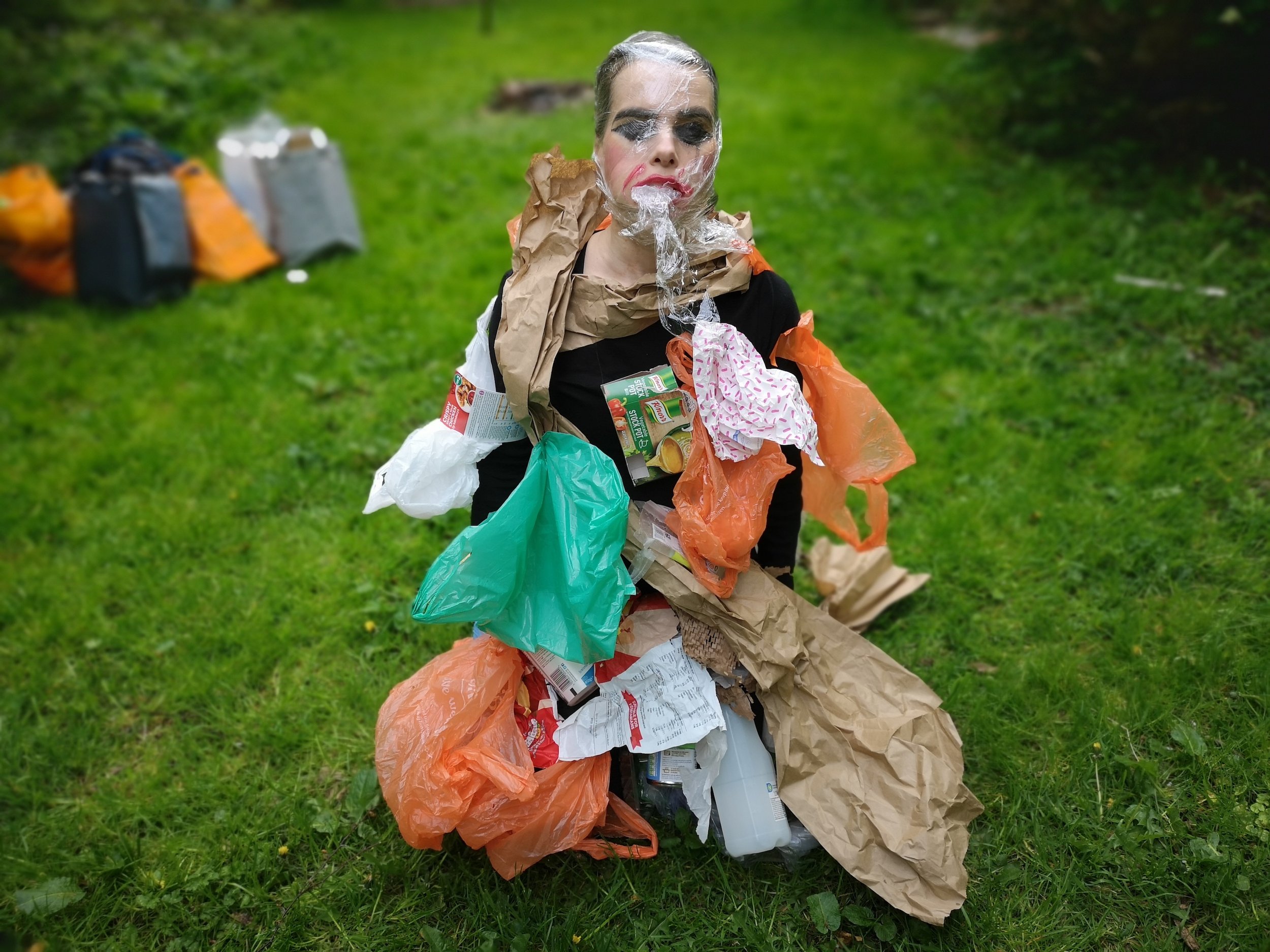 Earthing April, a woman clothed in rubbish.