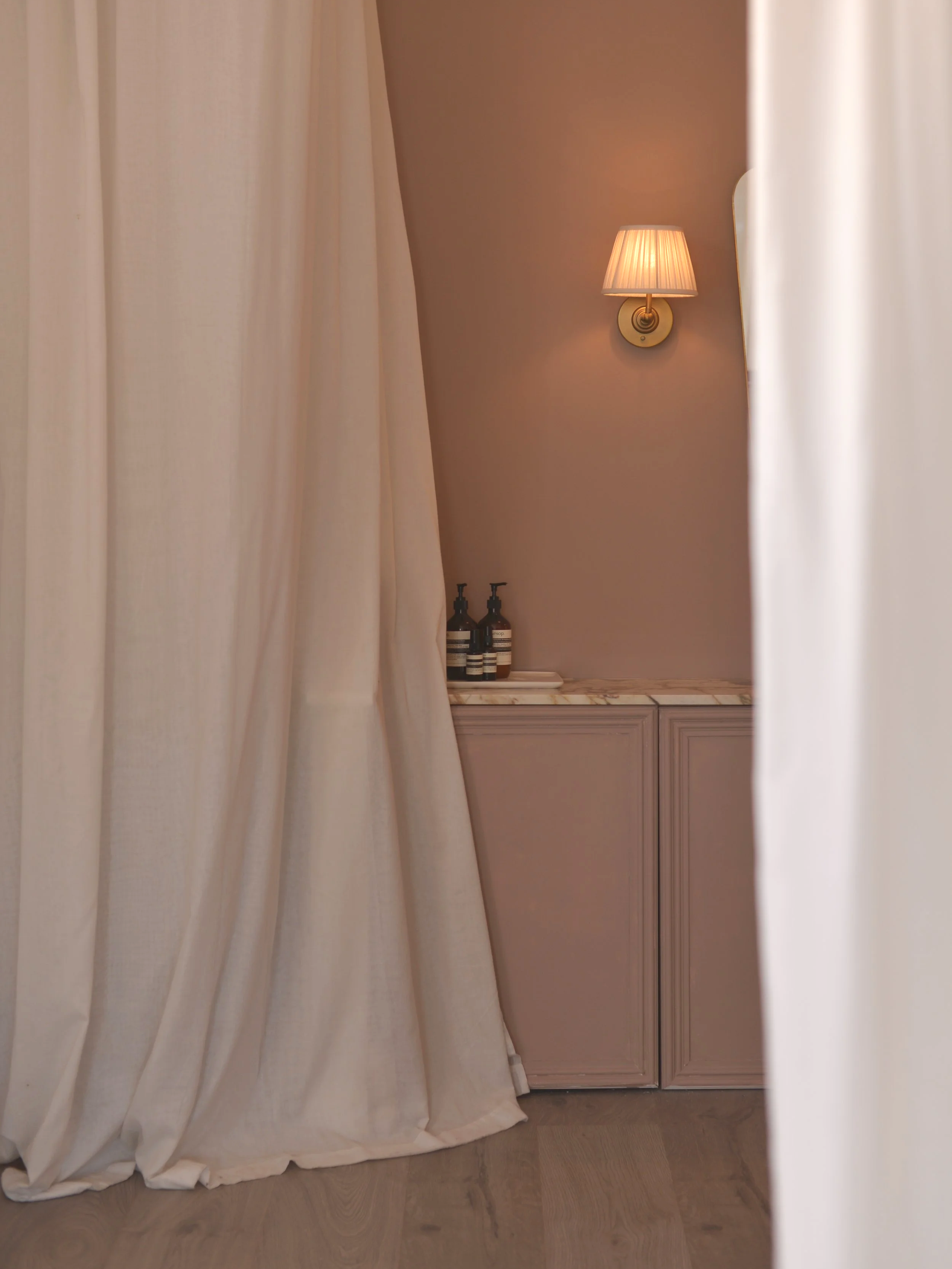 The vanity in our changing room - calcatta viola marble, linen wall lights and a mid century brass mirror