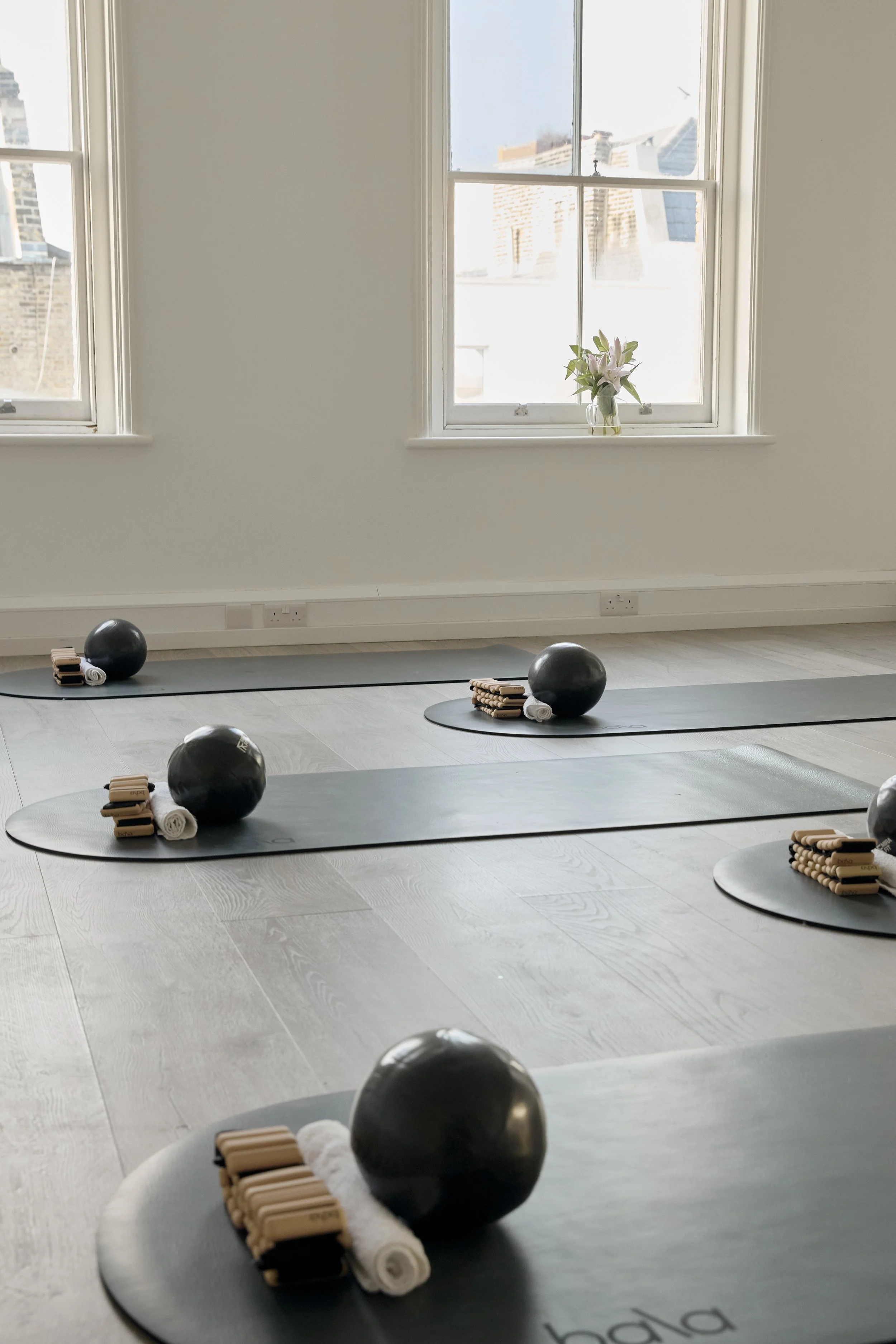 Room two - the studio space. Complete with two large arch mirrors, two large natural windows, wooden floors, curved Bala mats, black Pilates equipment