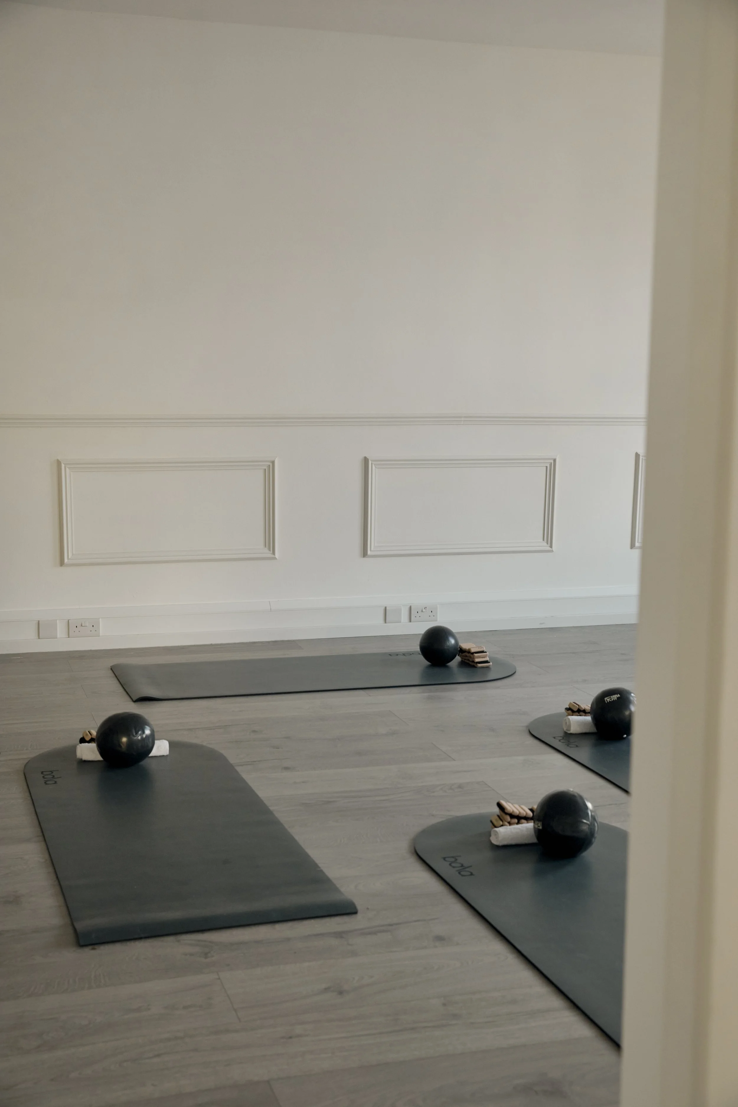Room two - the studio space. Complete with two large arch mirrors, two large natural windows, wooden floors, curved Bala mats, black Pilates equipment