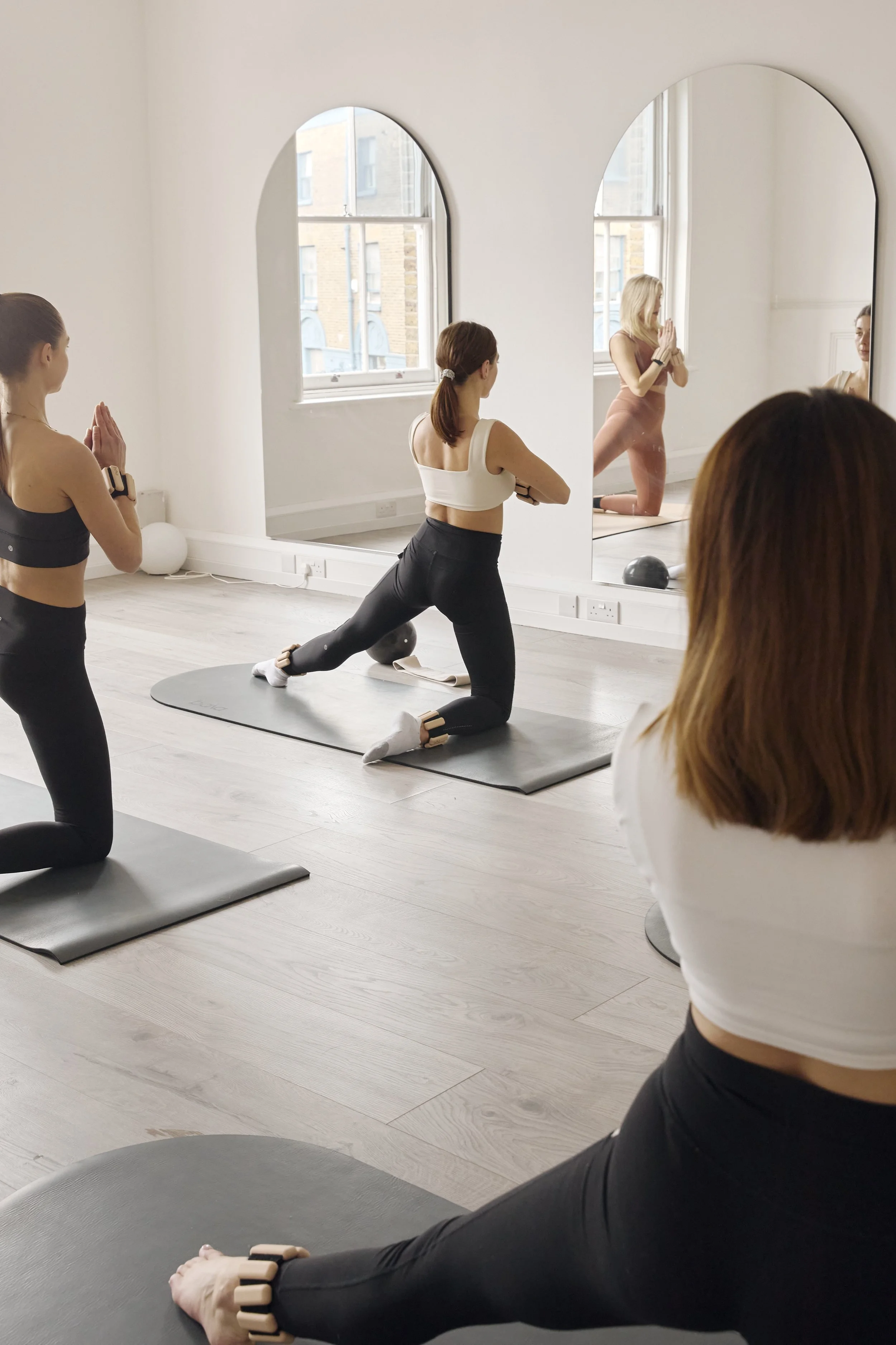 Room two - the studio space. Complete with two large arch mirrors, two large natural windows, wooden floors, curved Bala mats, black Pilates equipment