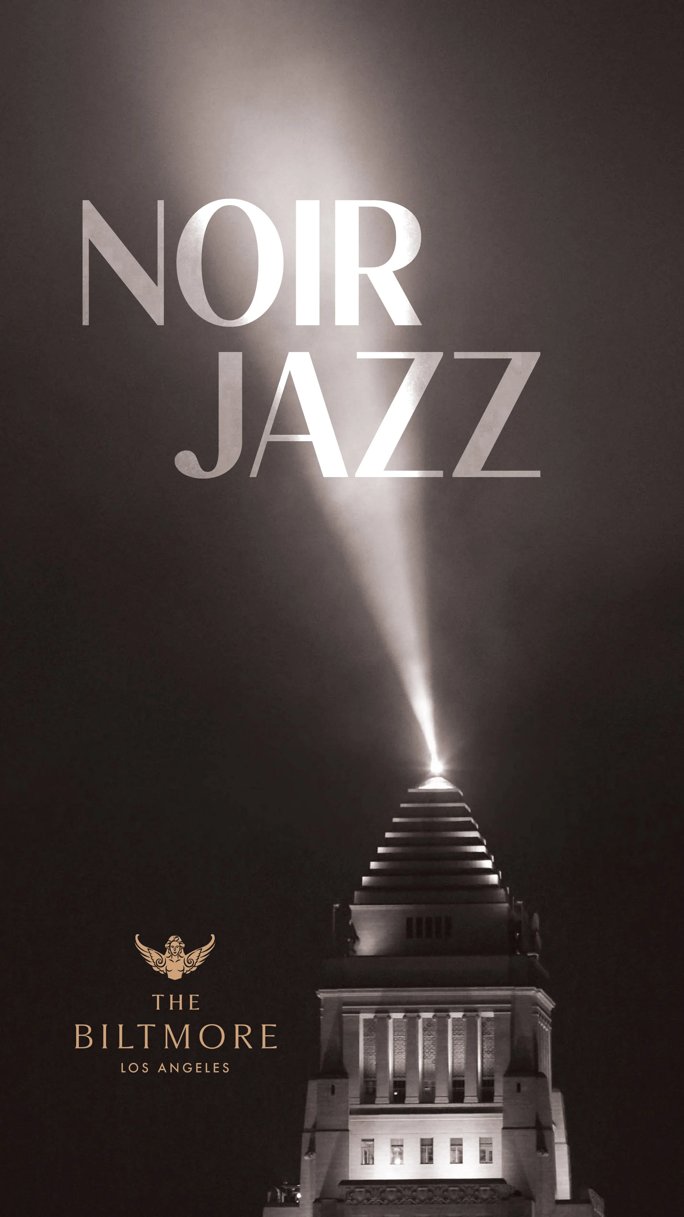 Night view of the top of the Biltmore building in Los Angeles, with a spotlight illuminating the text 'NOIR JAZZ' and a small logo near the bottom with the words 'The Biltmore Los Angeles'.