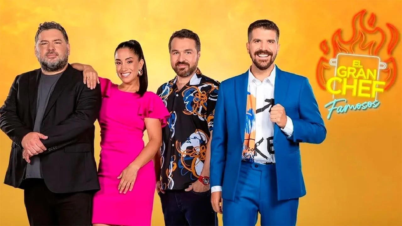 Four people standing together against a yellow background with a neon sign that says 'El Gran Chef Famosos' with flames.